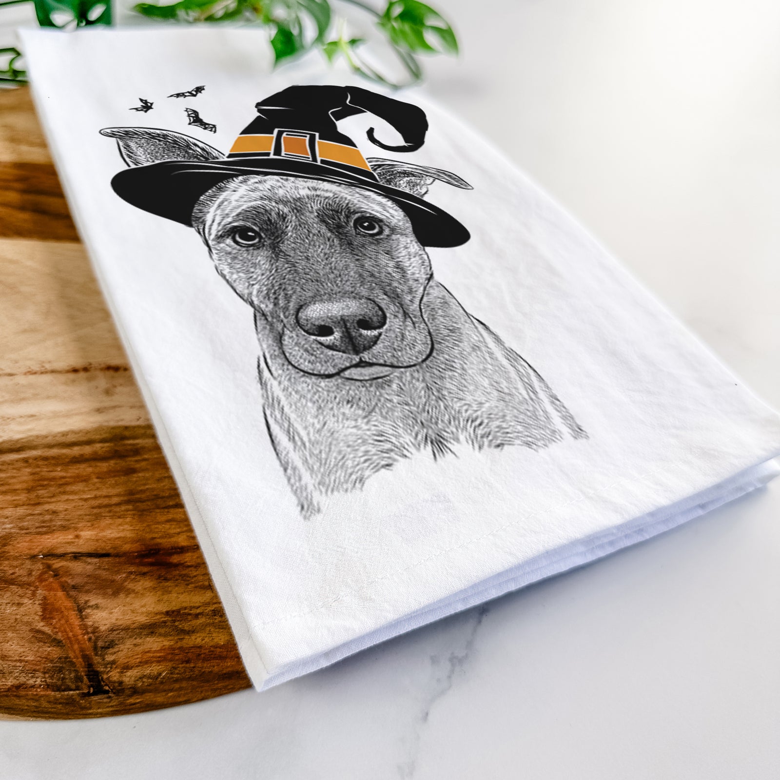 Hand-drawn sketch of Zoey the Mixed Breed wearing a witch hat on a tea towel