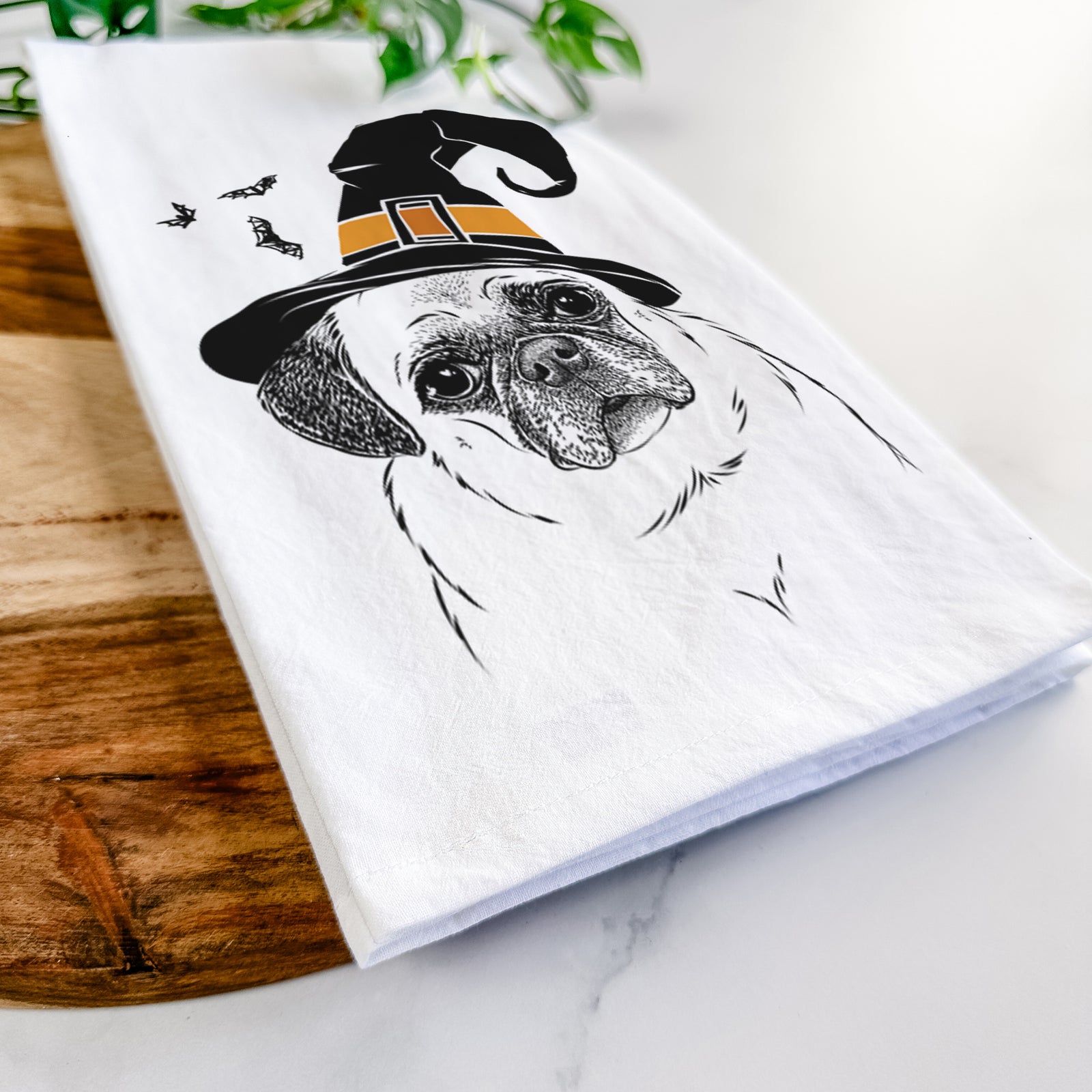 Hand-drawn sketch of Zoey the Pug wearing a witch hat on a tea towel