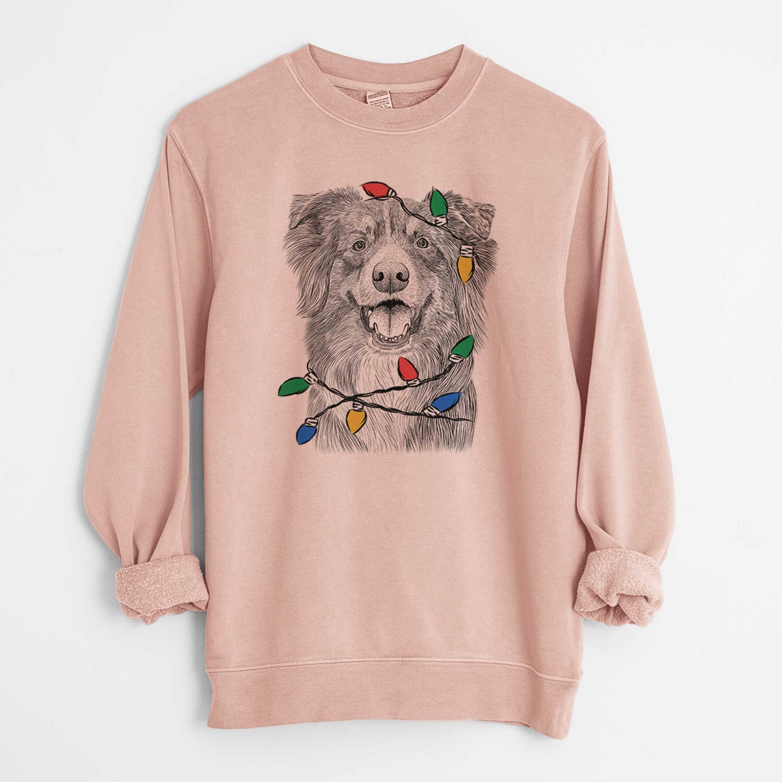 Hand-drawn sketch of Aussie Parker the Australian Shepherd wrapped in Christmas lights on a Dusty Pink Unisex pigment dyed crew sweatshirt