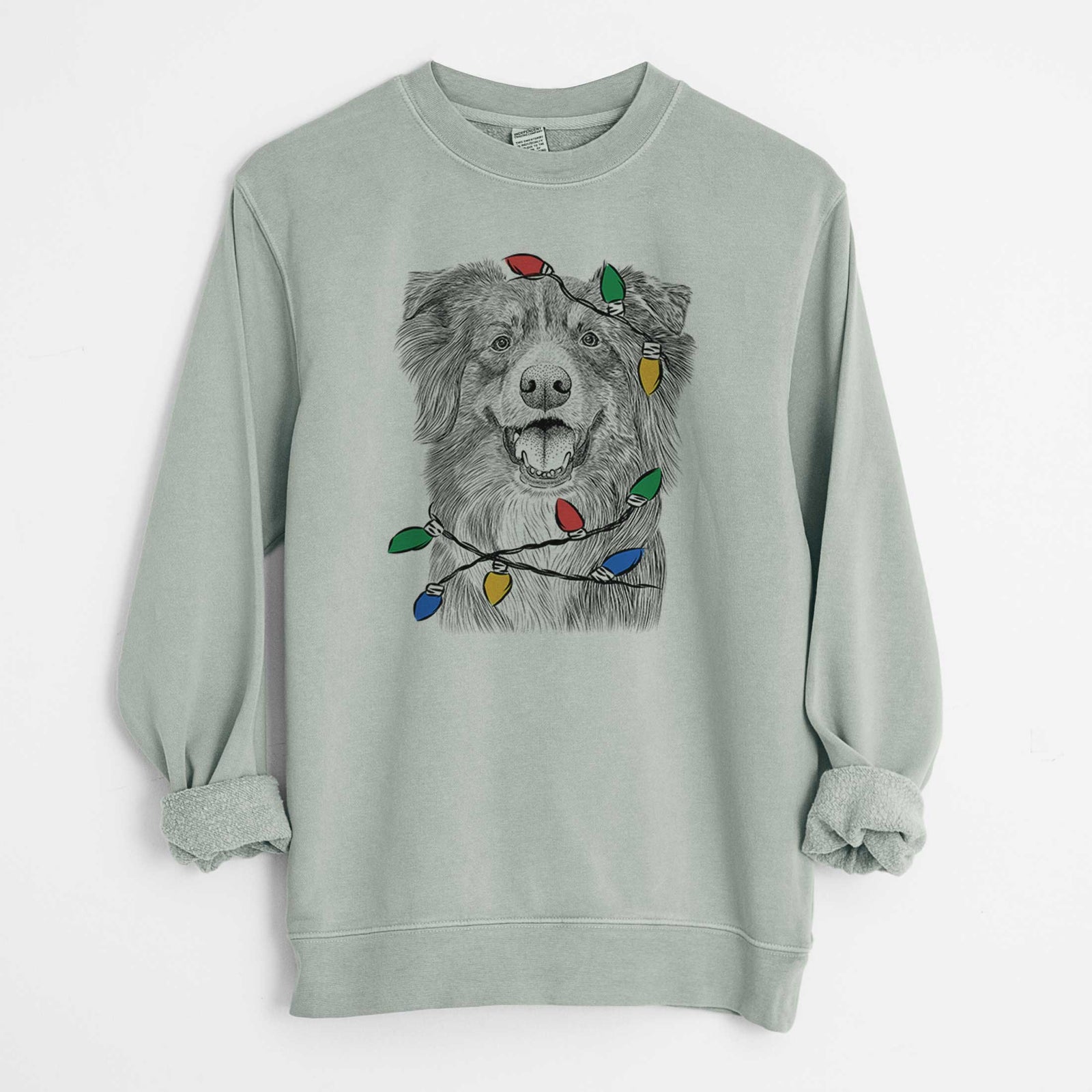 Hand-drawn sketch of Aussie Parker the Australian Shepherd wrapped in Christmas lights on a Sage Unisex pigment dyed crew sweatshirt