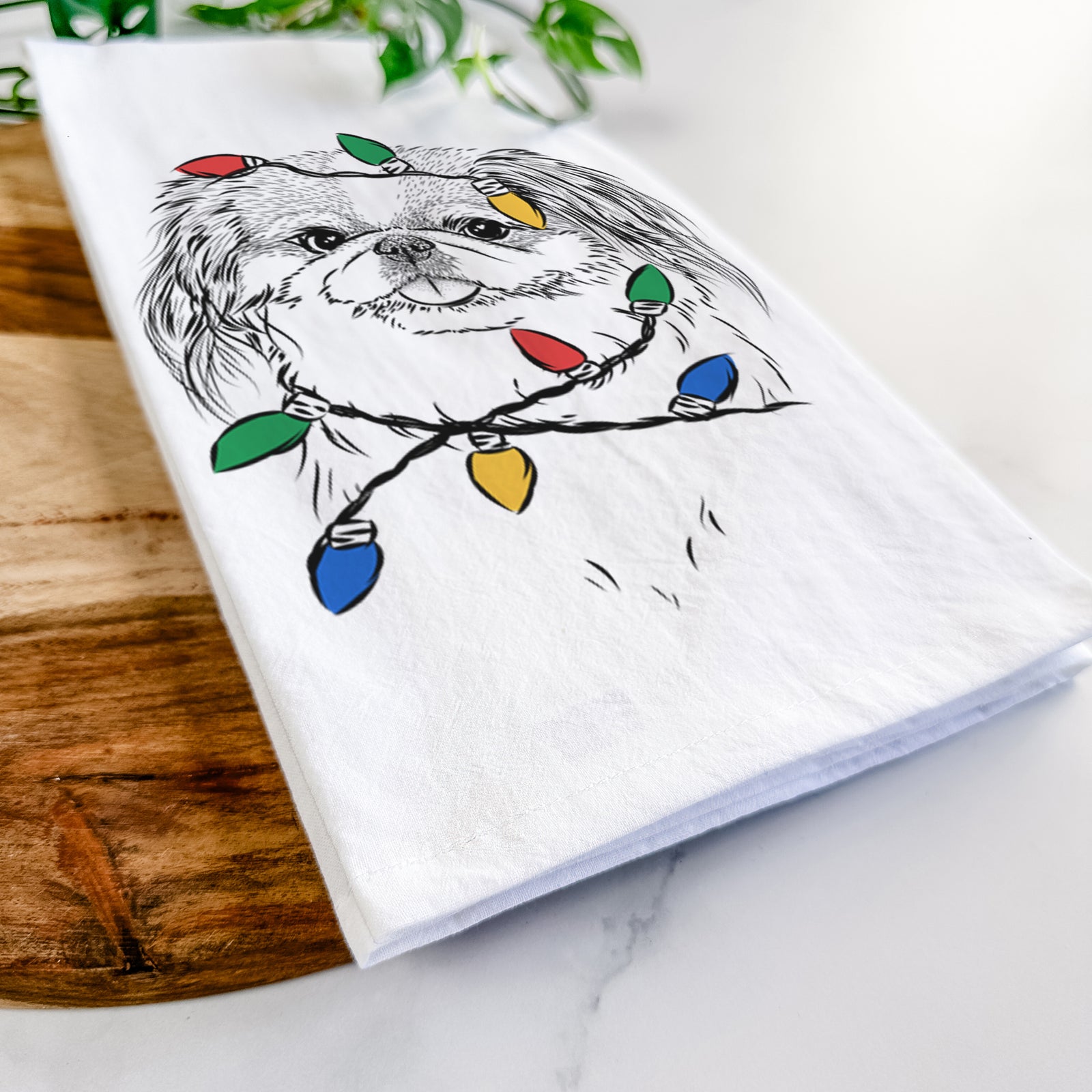Hand-drawn sketch of Abra Bean the Pekingese wrapped in Christmas lights on a tea towel