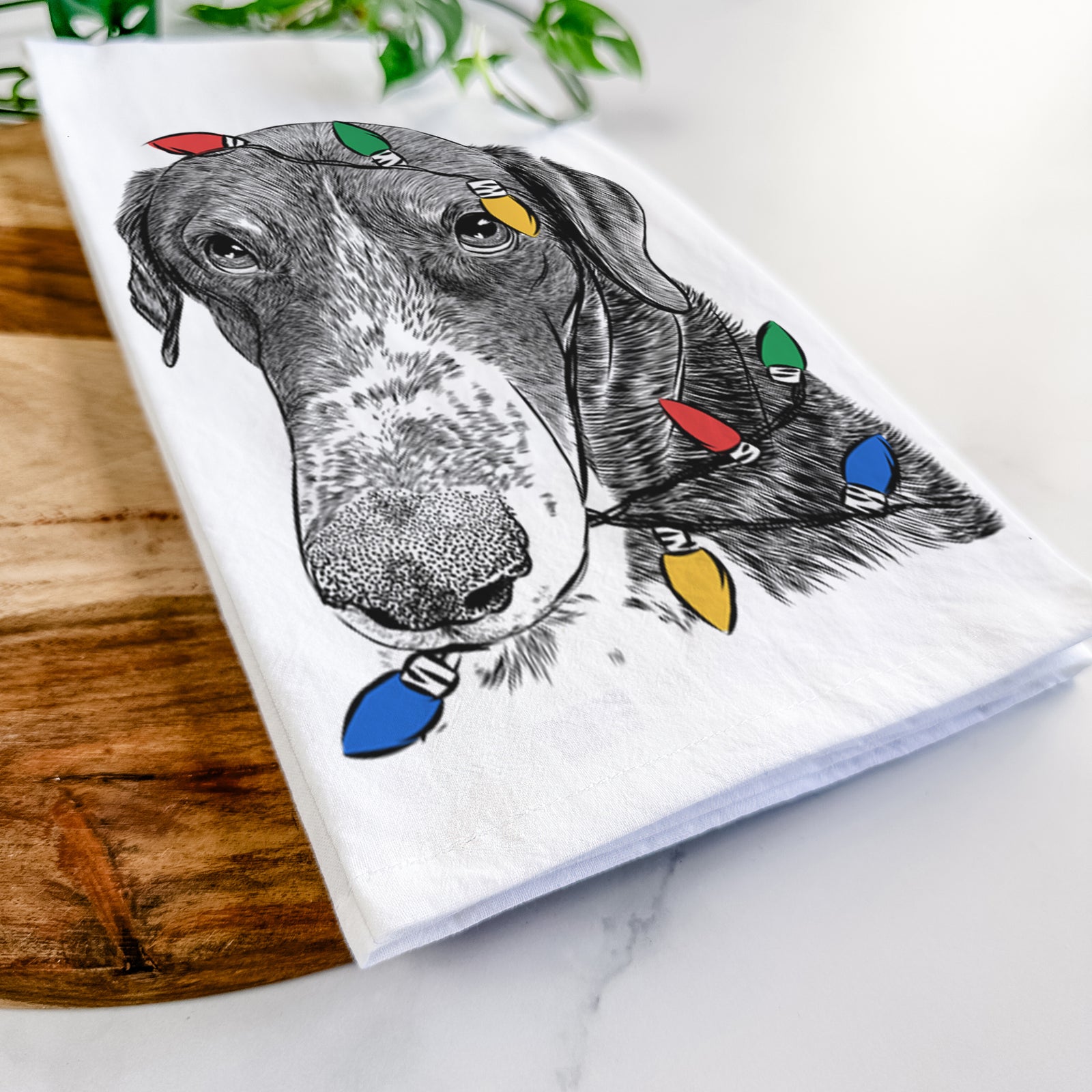 Hand-drawn sketch of Angel Orion the Mixed Breed wrapped in Christmas lights on a tea towel