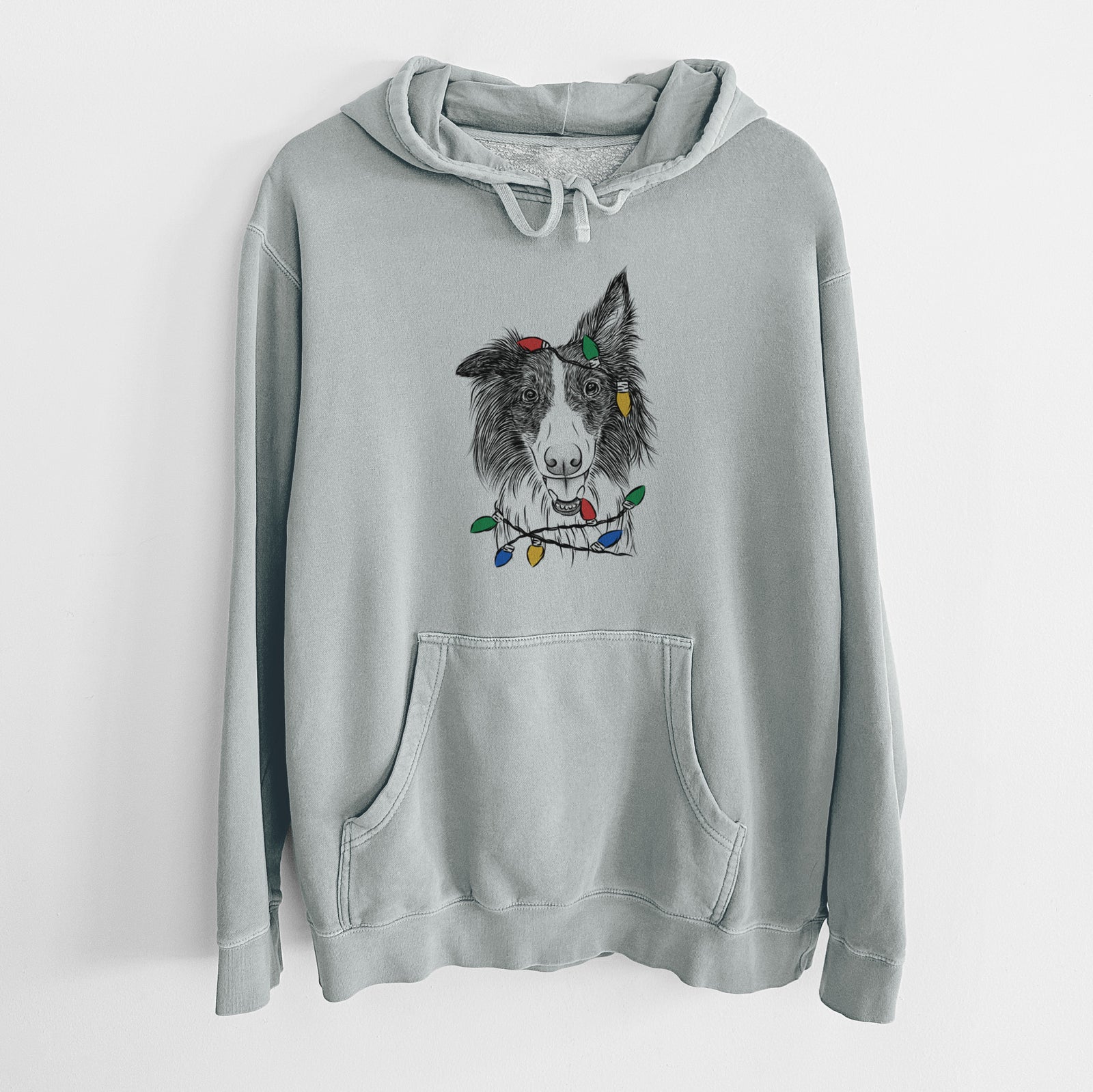 Hand-drawn sketch of Archie the Silken Windhound wrapped in Christmas lights on a Sage Unisex pigment dyed hoodie