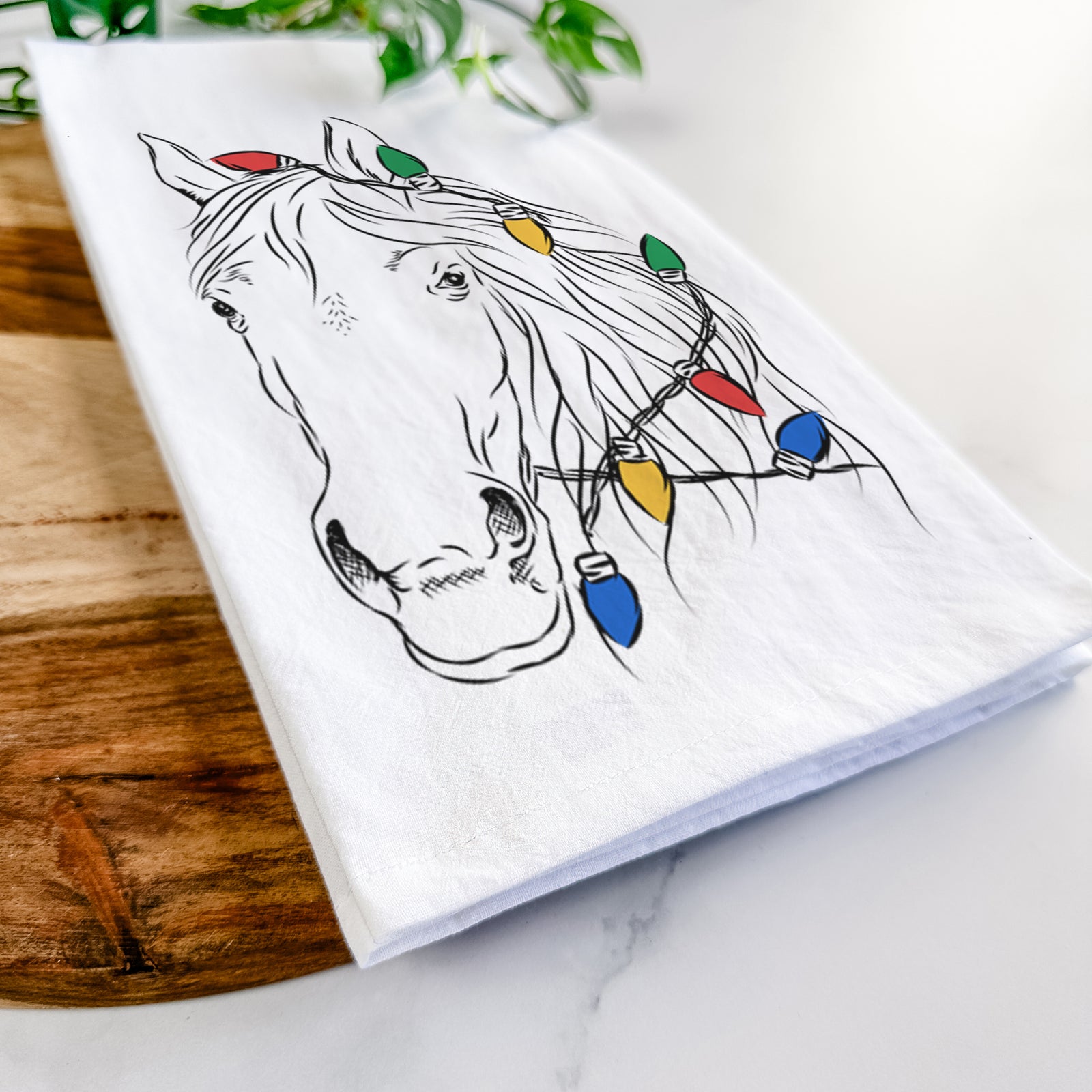 Hand-drawn sketch of Aria the Horse wrapped in Christmas lights on a tea towel