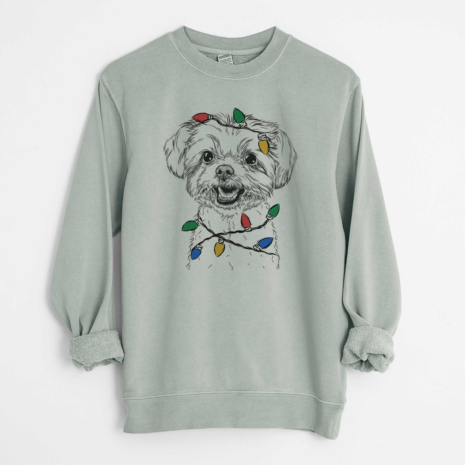 Hand-drawn sketch of Aspen the Morkie wrapped in Christmas lights on a Sage Unisex pigment dyed crew sweatshirt