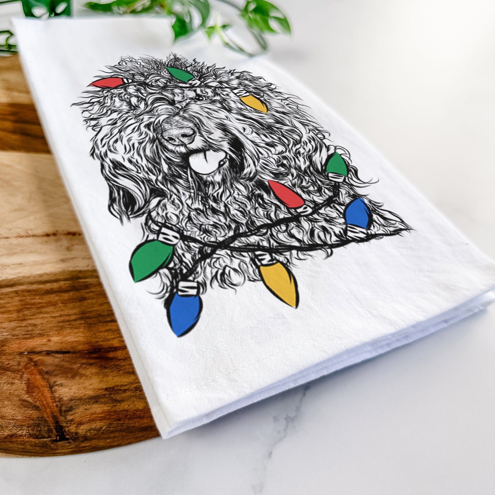 Hand-drawn sketch of Babs the Barbet wrapped in Christmas lights on a tea towel