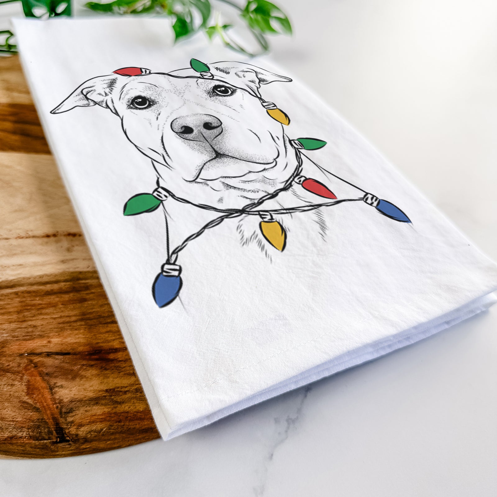 Hand-drawn sketch of Bailey the American Staffordshire Terrier wrapped in Christmas lights on a tea towel