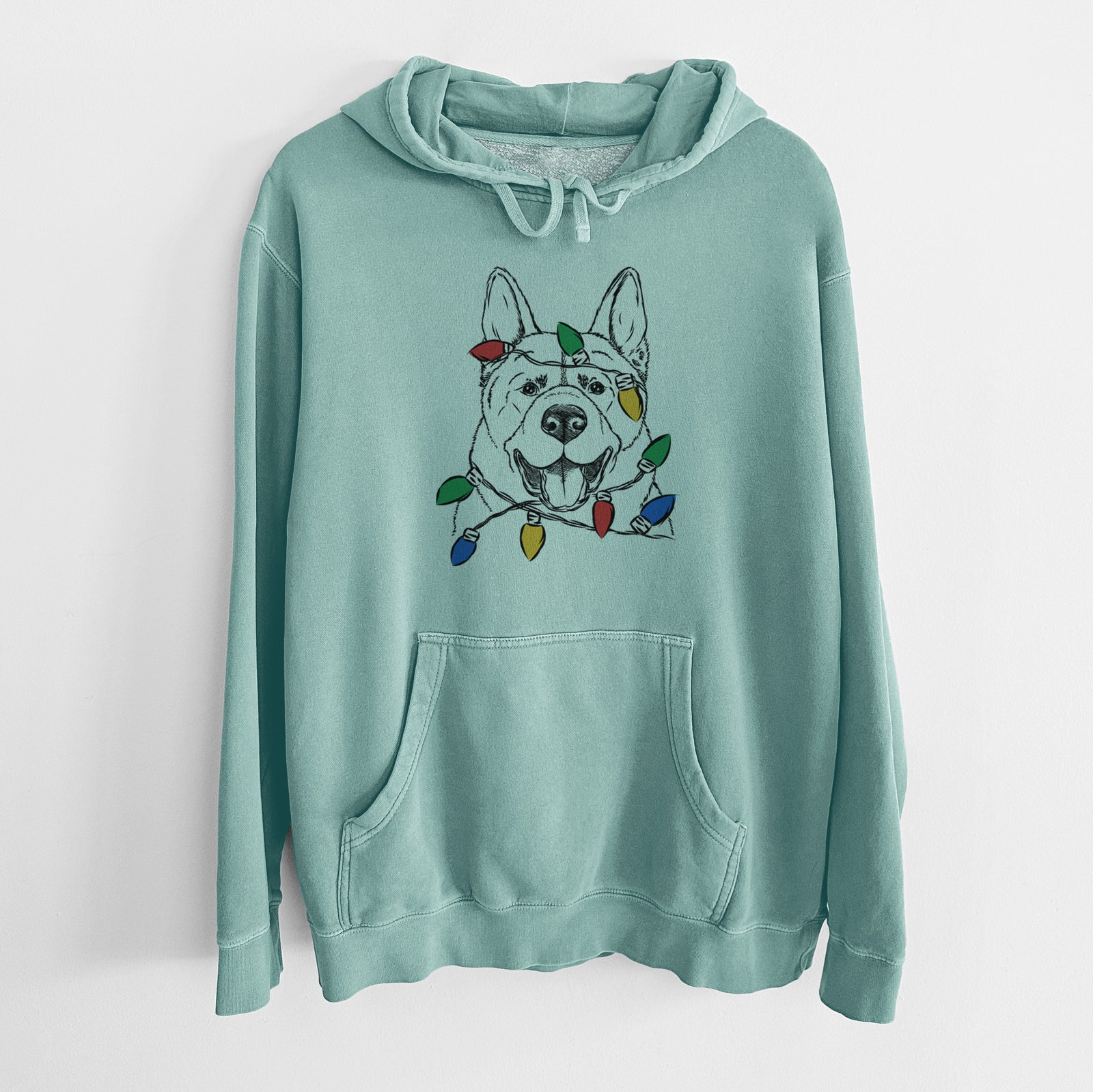 Hand-drawn sketch of Baku the Akita wrapped in Christmas lights on a Mint Unisex pigment dyed hoodie