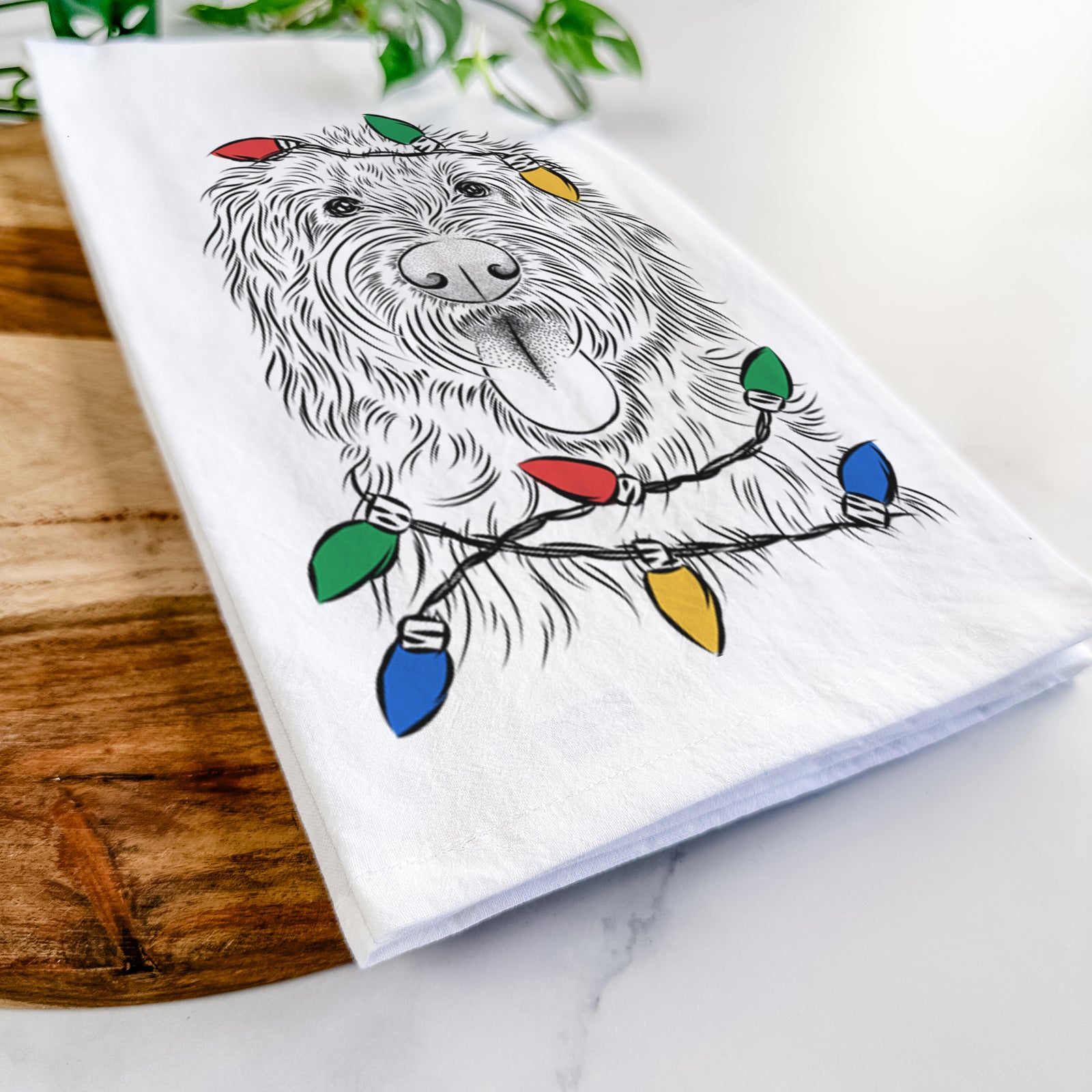 Hand-drawn sketch of Bennett the Doodle wrapped in Christmas lights on a tea towel