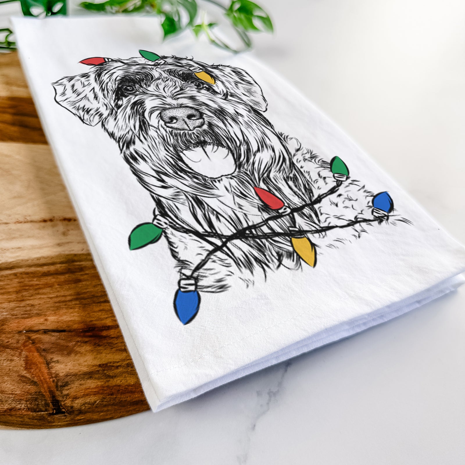 Hand-drawn sketch of Bonnie the Bouvier Des Flandres wrapped in Christmas lights on a tea towel