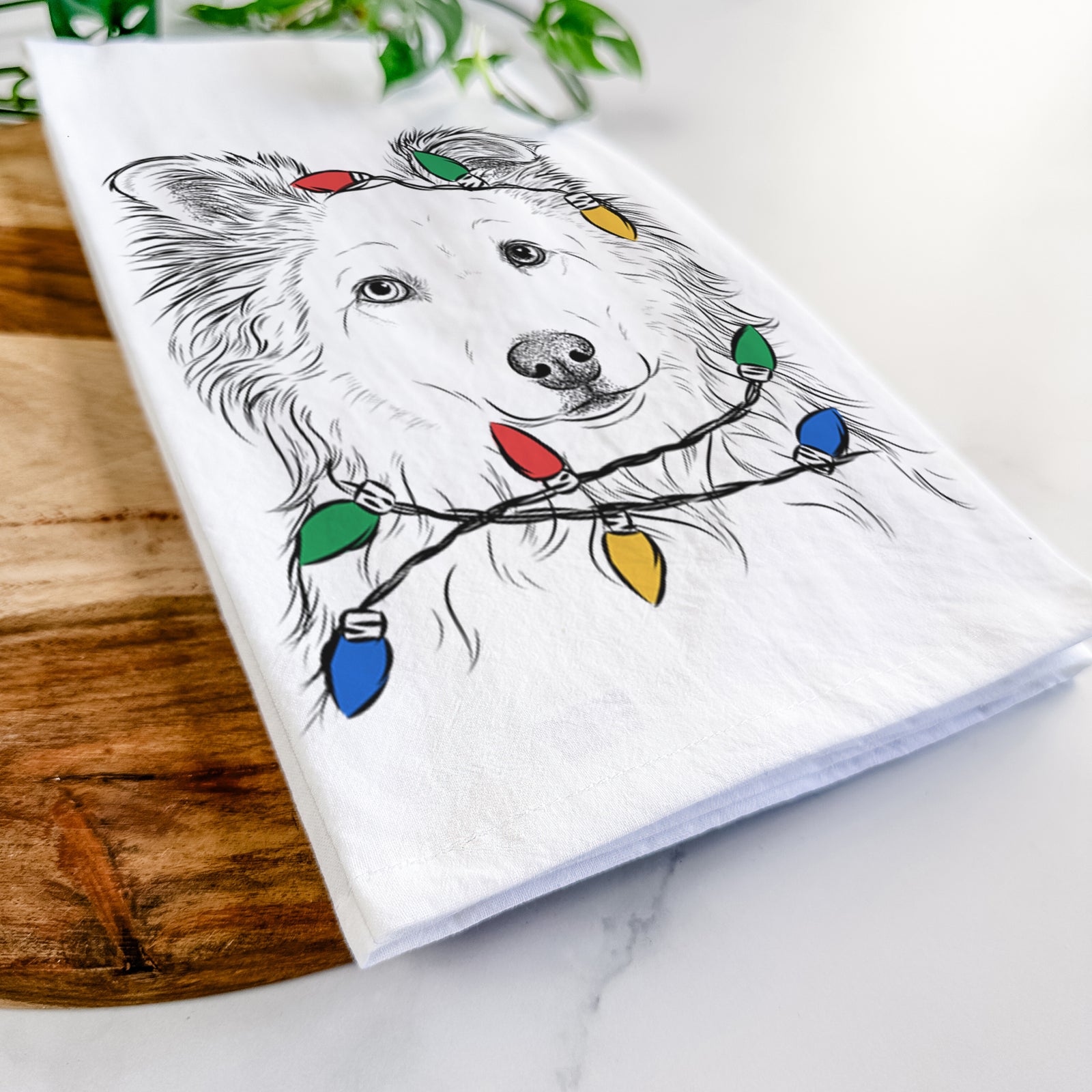 Hand-drawn sketch of Bonsai the Mixed Breed wrapped in Christmas lights on a tea towel