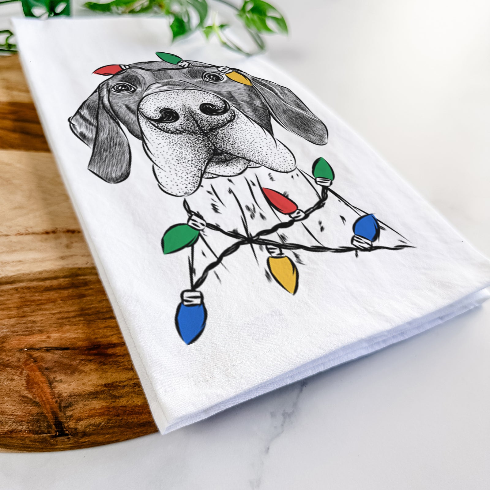 Hand-drawn sketch of Booze the German Shorthaired Pointer wrapped in Christmas lights on a tea towel