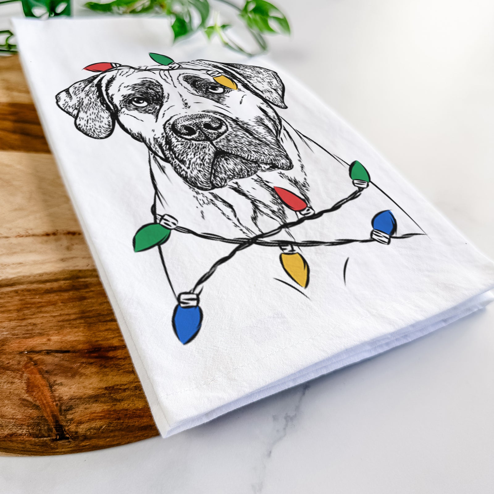 Hand-drawn sketch of Boris the Boerboel wrapped in Christmas lights on a tea towel
