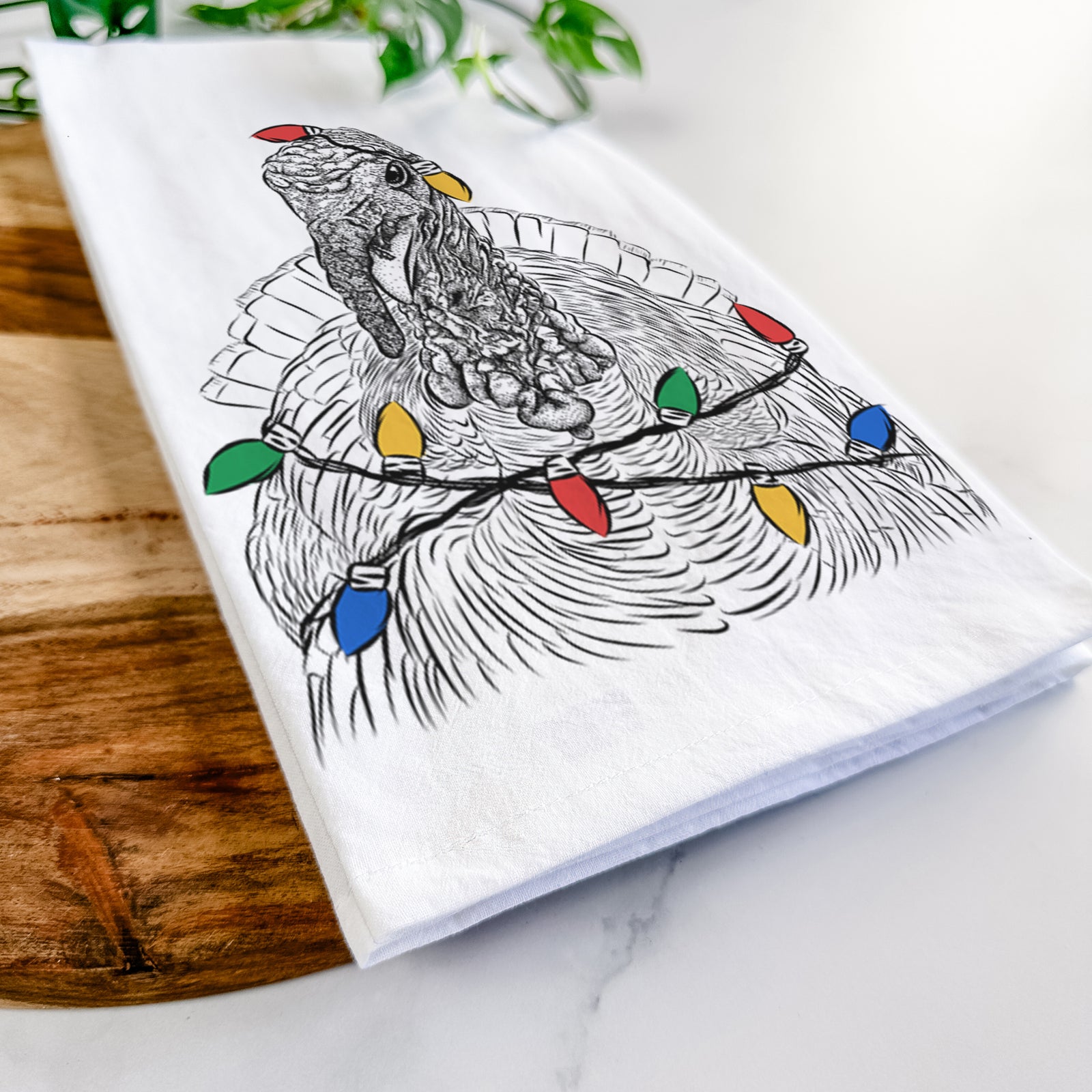 Hand-drawn sketch of Brady the Turkey wrapped in Christmas lights on a tea towel