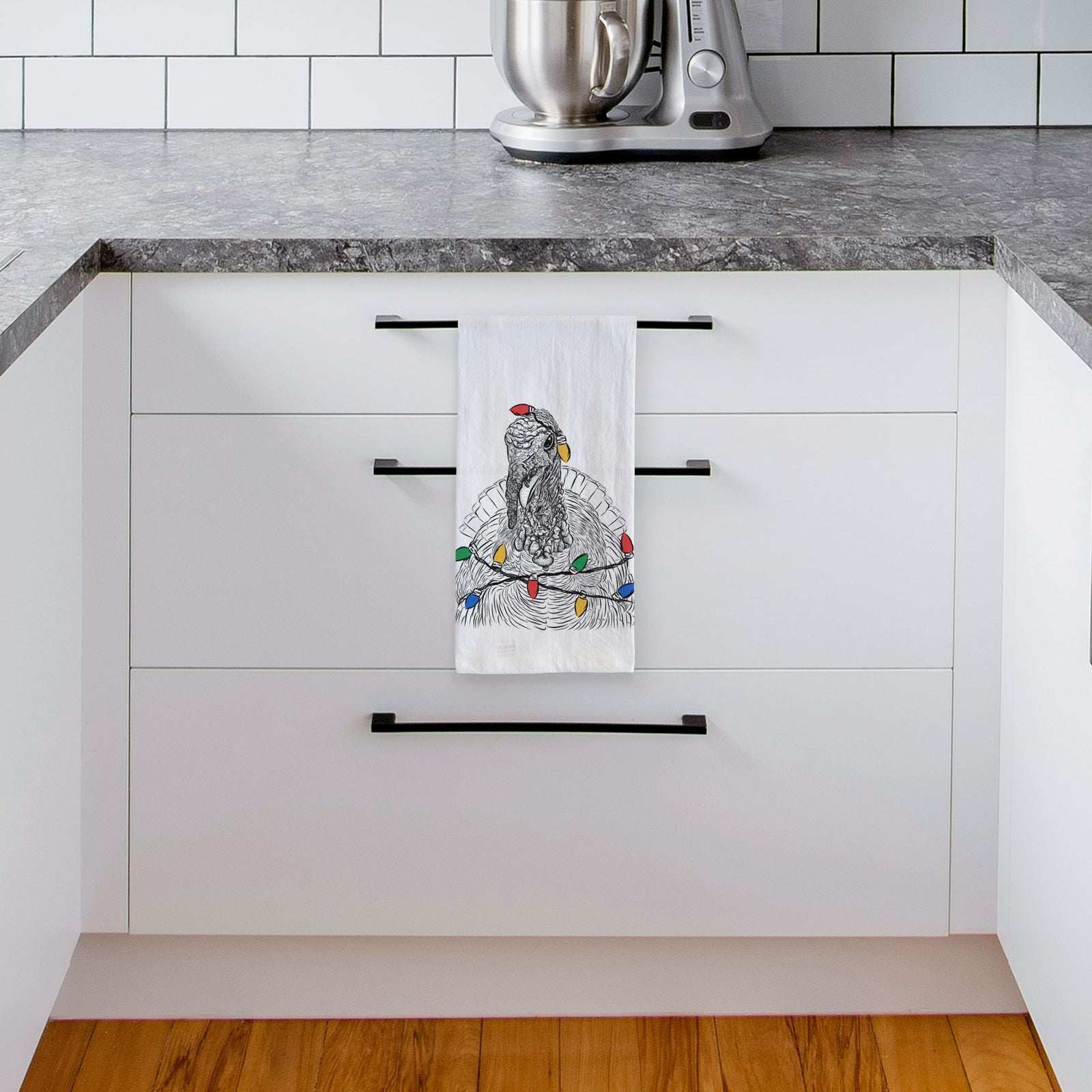 Hand-drawn sketch of Brady the Turkey wrapped in Christmas lights on a tea towel, hanging on an oven door in a kitchen