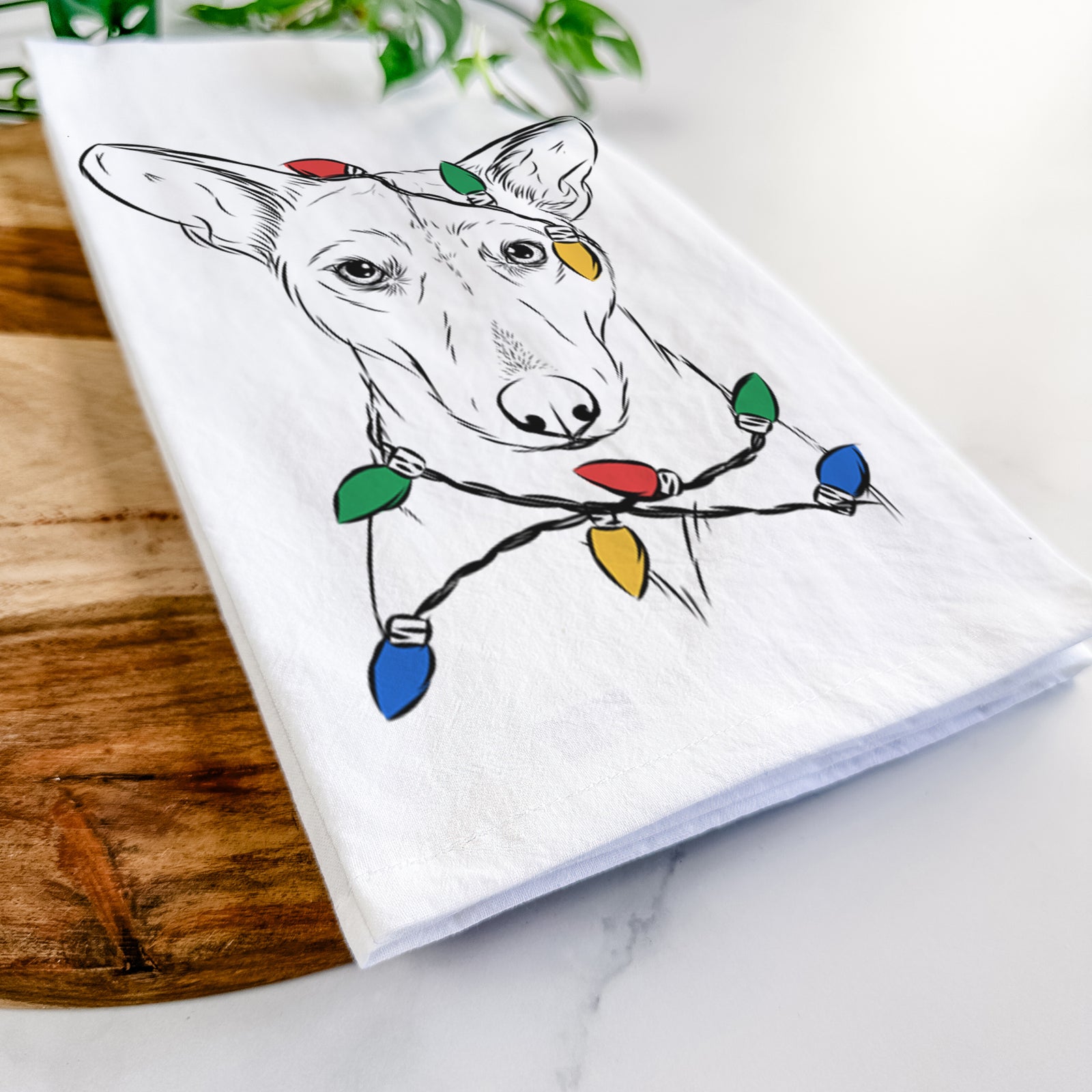 Hand-drawn sketch of Buff the Dorgi wrapped in Christmas lights on a tea towel