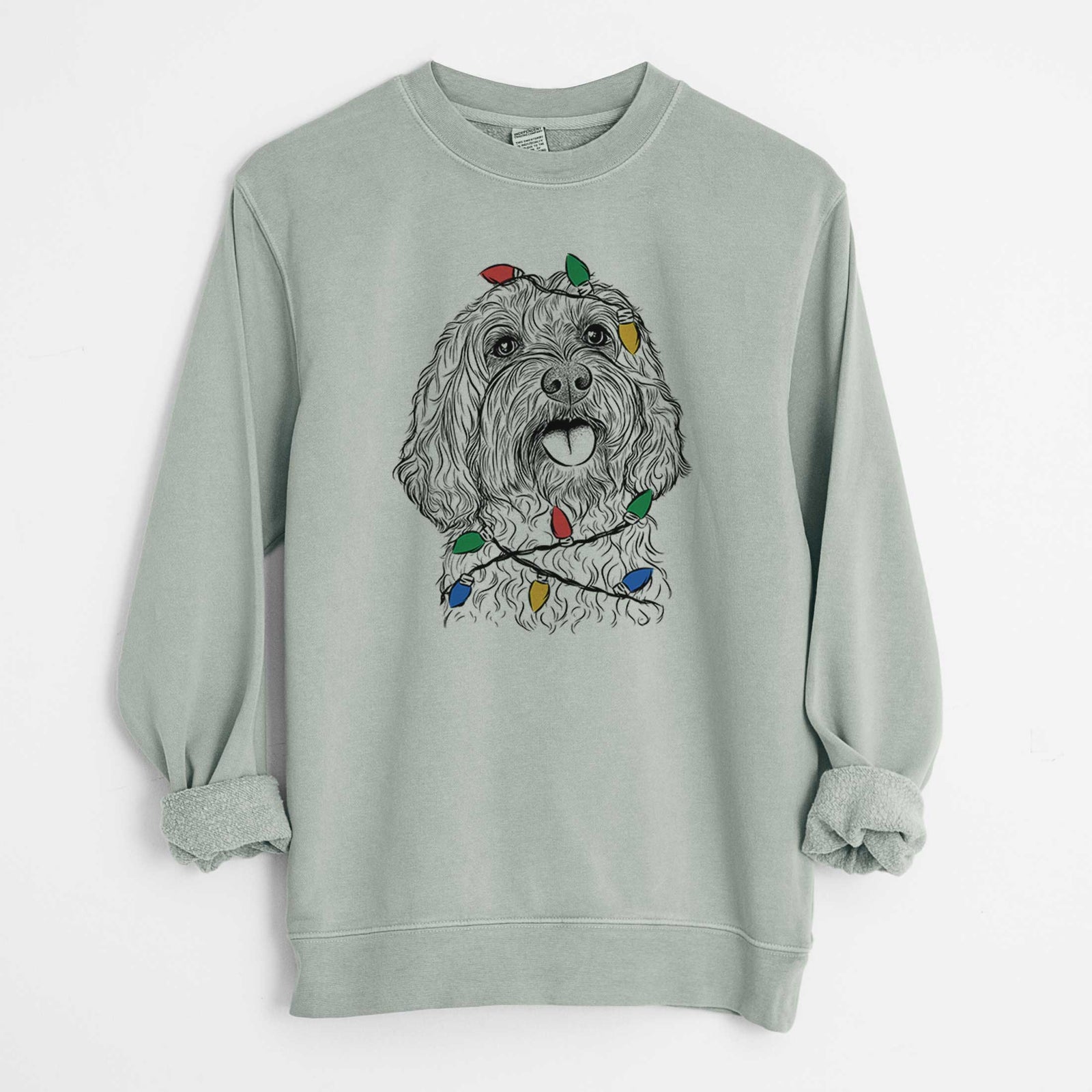 Hand-drawn sketch of Cali the Cavapoo wrapped in Christmas lights on a Sage Unisex pigment dyed crew sweatshirt
