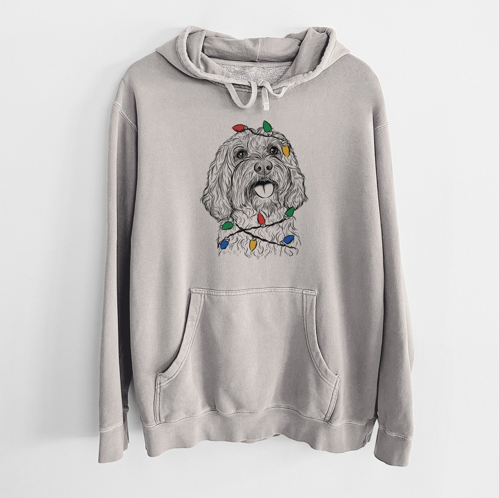 Hand-drawn sketch of Cali the Cavapoo wrapped in Christmas lights on a Cement Unisex pigment dyed hoodie