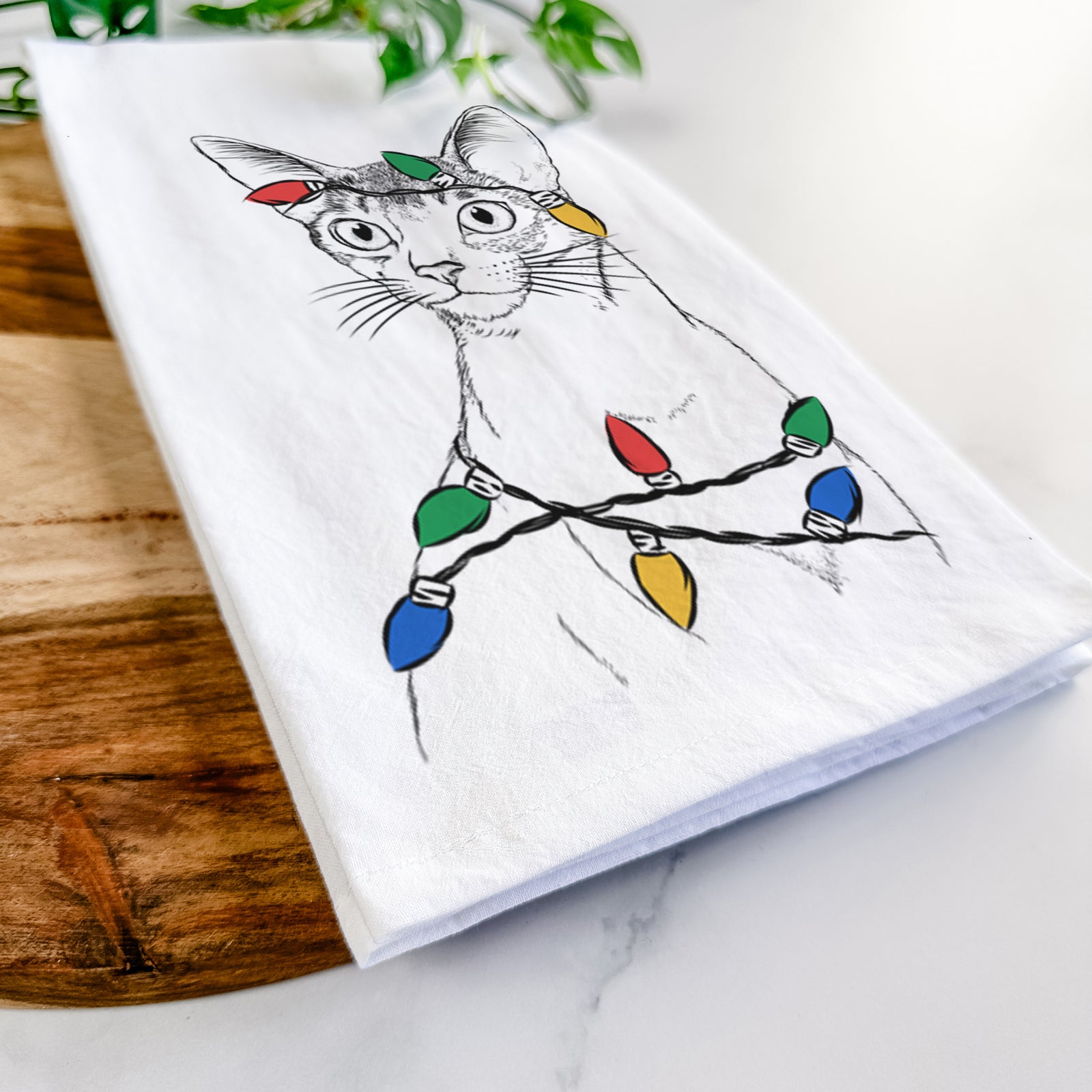 Hand-drawn sketch of Cedric the Abyssinian Cat wrapped in Christmas lights on a tea towel