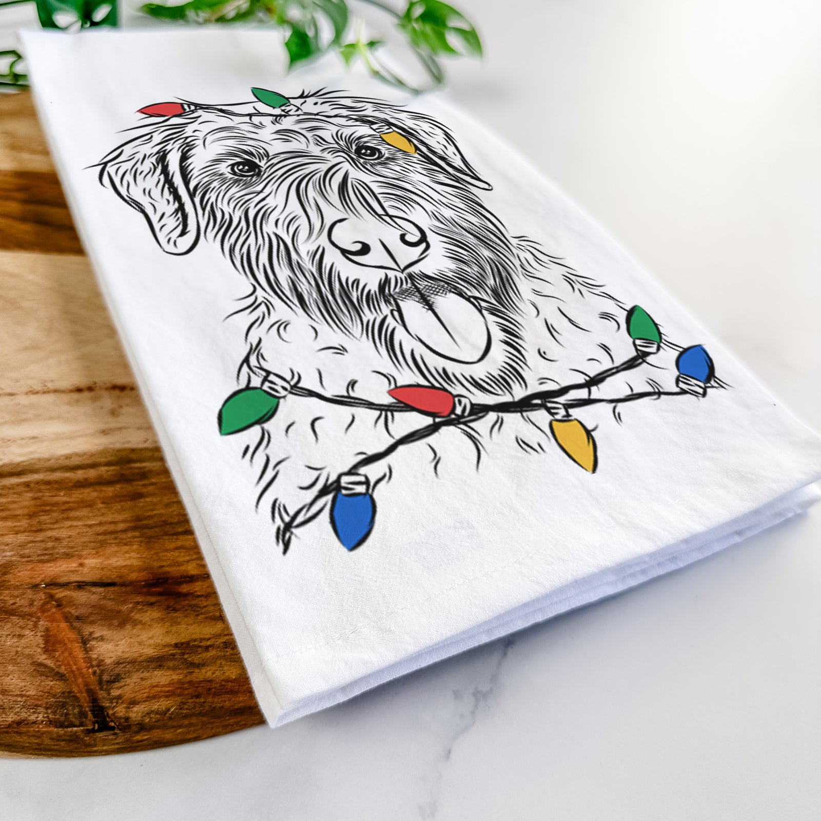 Hand-drawn sketch of Chester the Soft Coated Wheaten Terrier wrapped in Christmas lights on a tea towel
