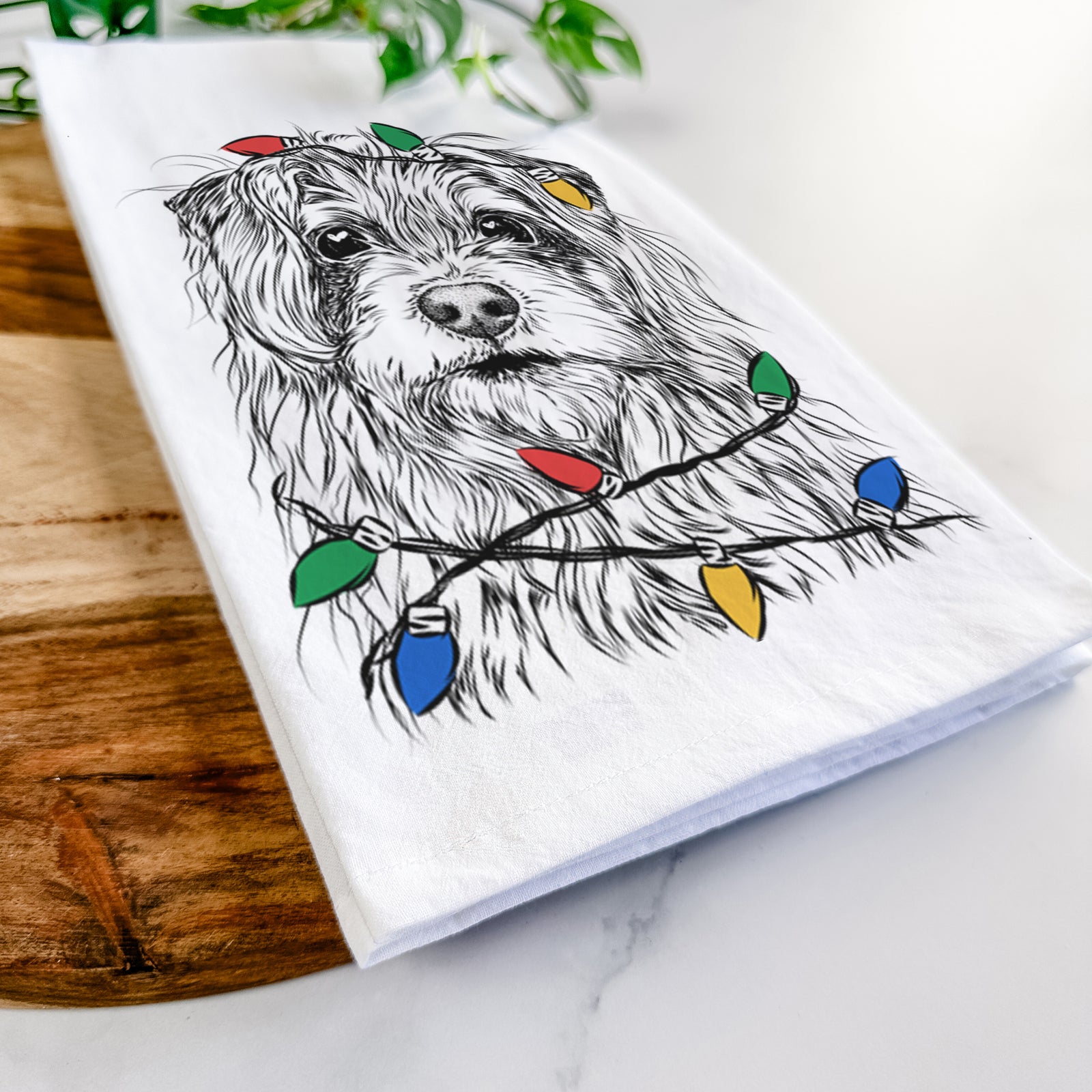 Hand-drawn sketch of Chester the Terrier Mix wrapped in Christmas lights on a tea towel