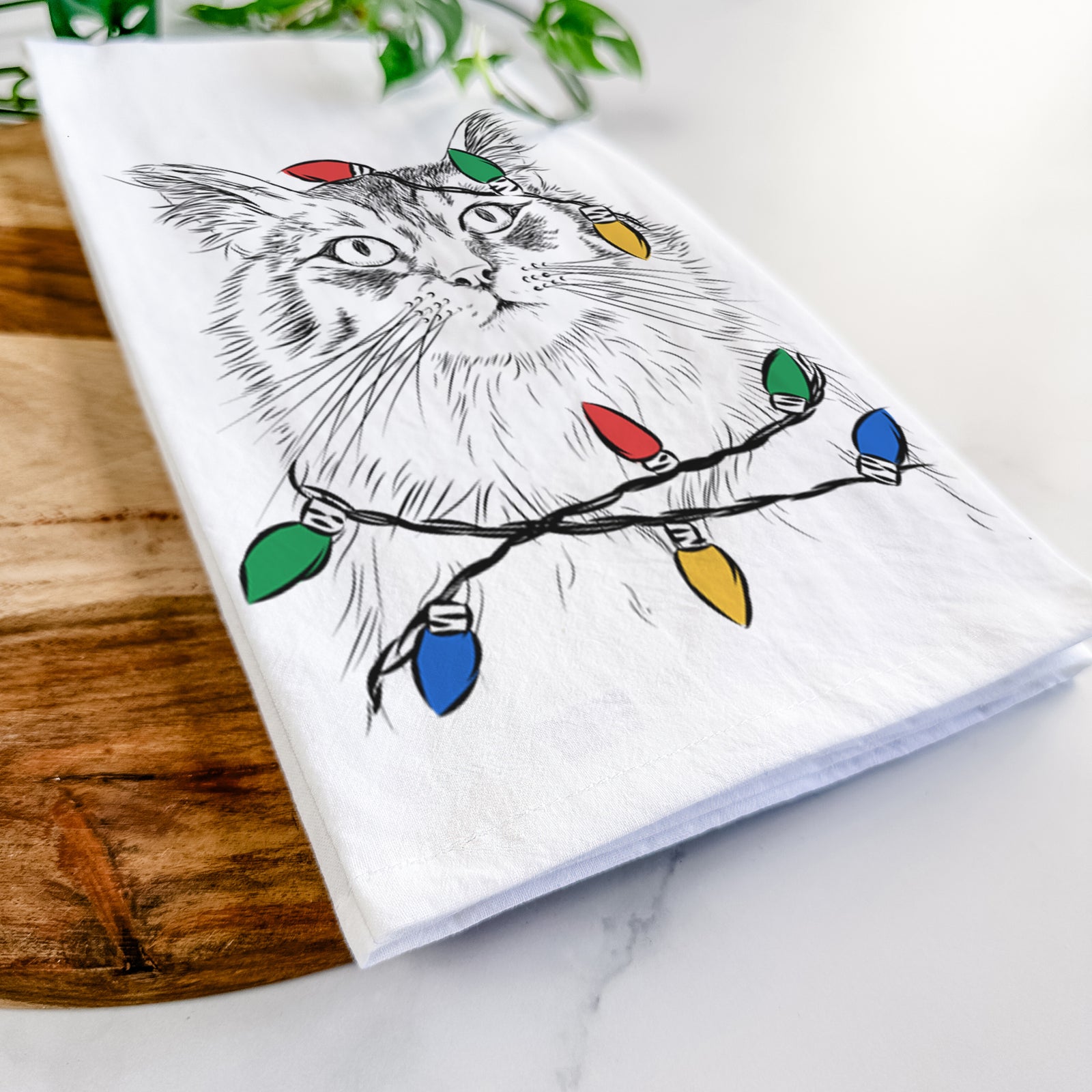 Hand-drawn sketch of Chloe the Tabby Cat wrapped in Christmas lights on a tea towel