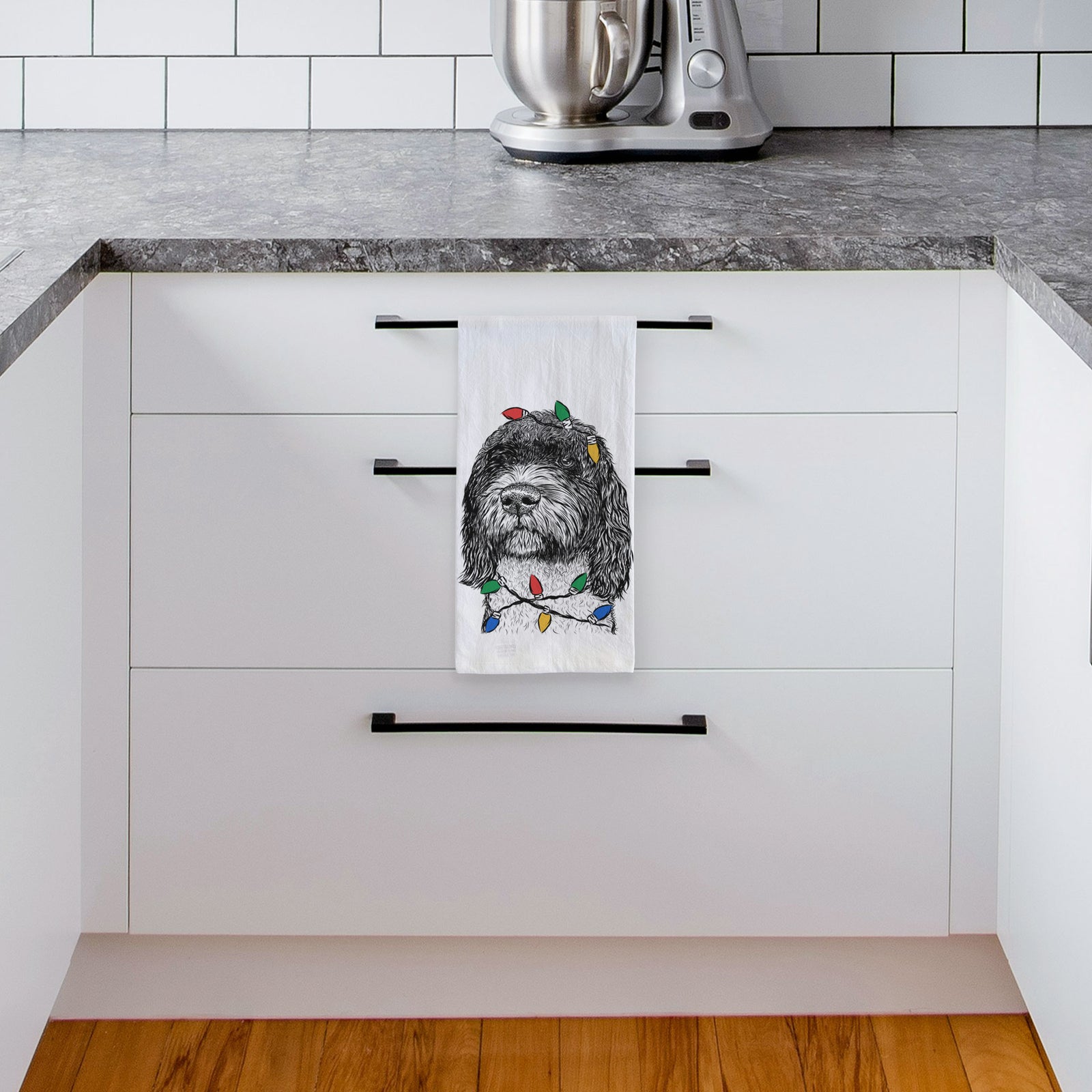 Hand-drawn sketch of Chris the Portuguese Water Dog wrapped in Christmas lights on a tea towel, hanging on an oven door in a kitchen