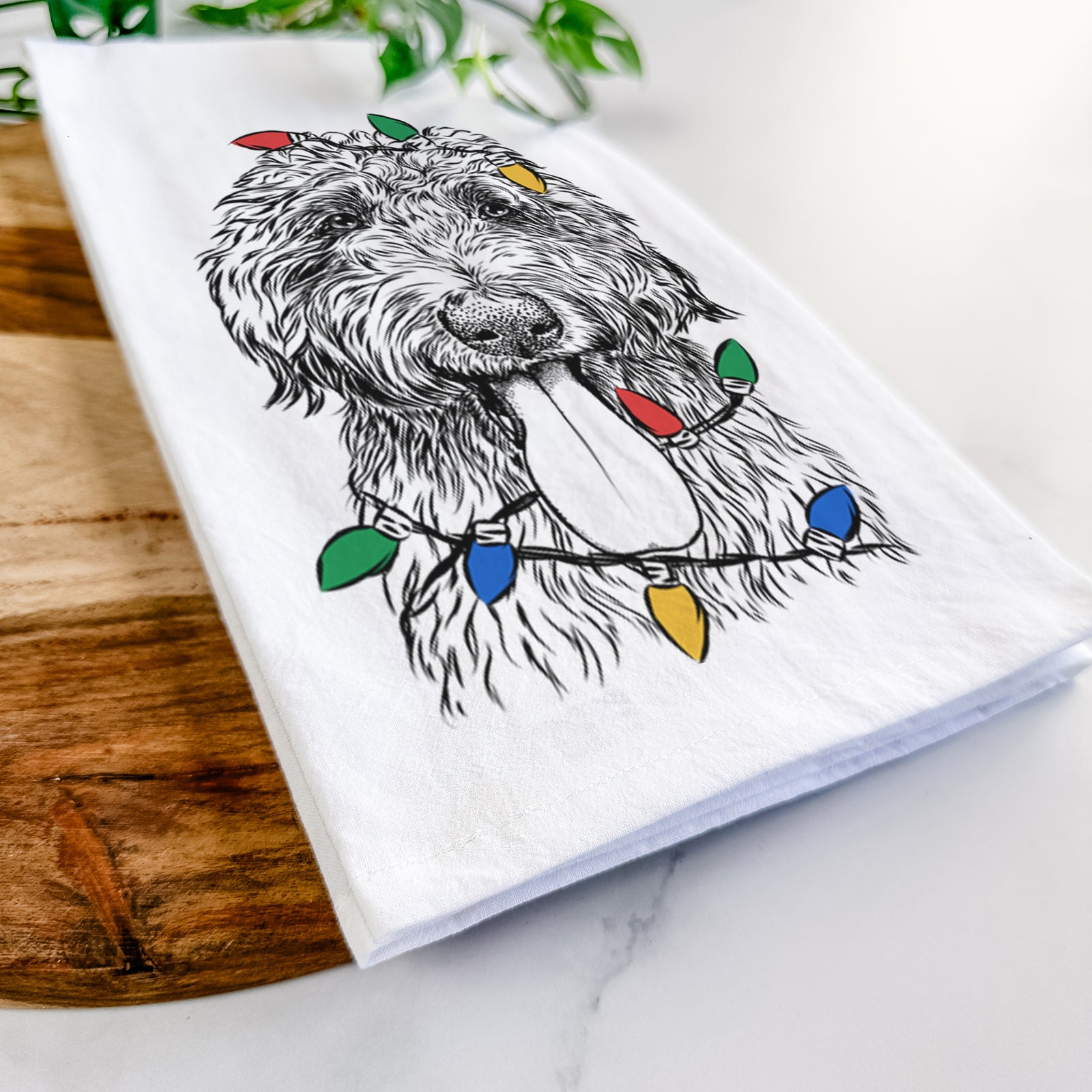 Hand-drawn sketch of CiCi Paulk the Aussiedoodle wrapped in Christmas lights on a tea towel