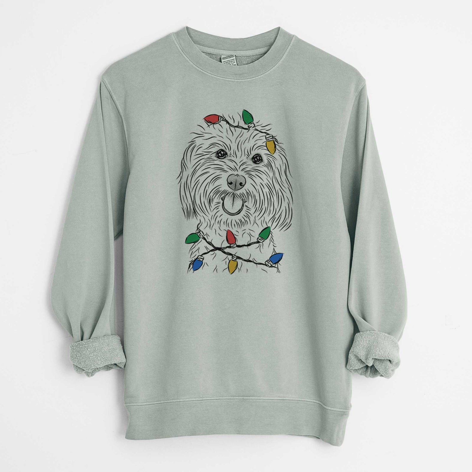 Hand-drawn sketch of Cuddles the Coton de Tulear wrapped in Christmas lights on a Sage Unisex pigment dyed crew sweatshirt