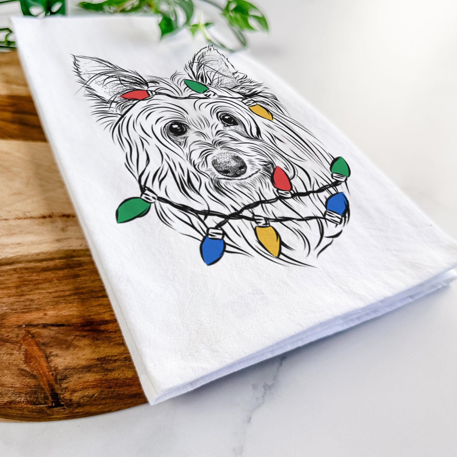 Hand-drawn sketch of Daisy May the Silky Terrier wrapped in Christmas lights on a tea towel