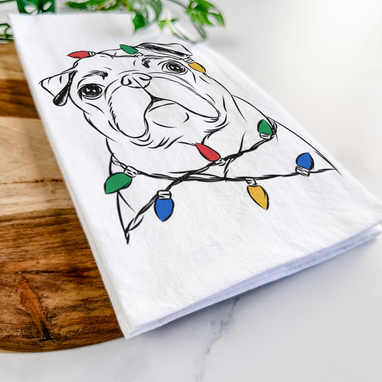 Hand-drawn sketch of Darling Chloe the Pug wrapped in Christmas lights on a tea towel