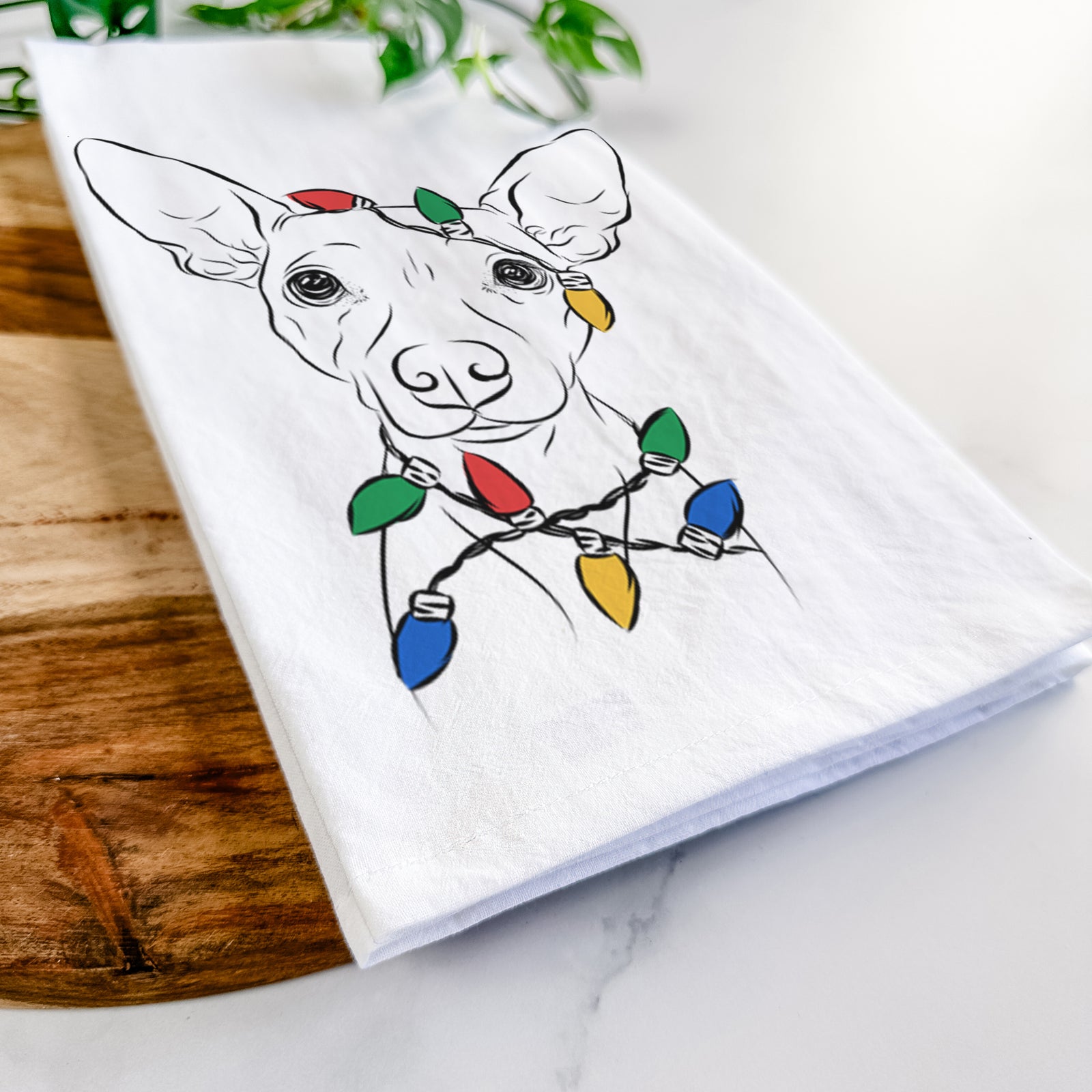 Hand-drawn sketch of Desi the American Hairless Terrier wrapped in Christmas lights on a tea towel