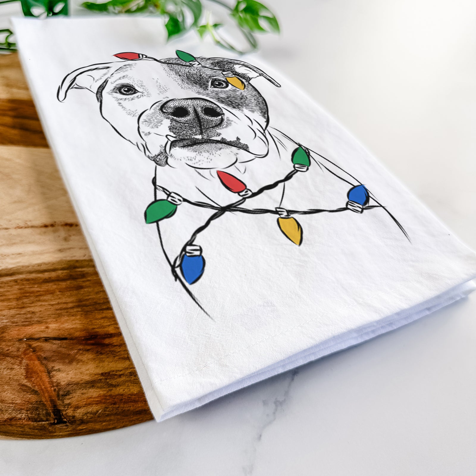 Hand-drawn sketch of Dexter the Pitbull wrapped in Christmas lights on a tea towel