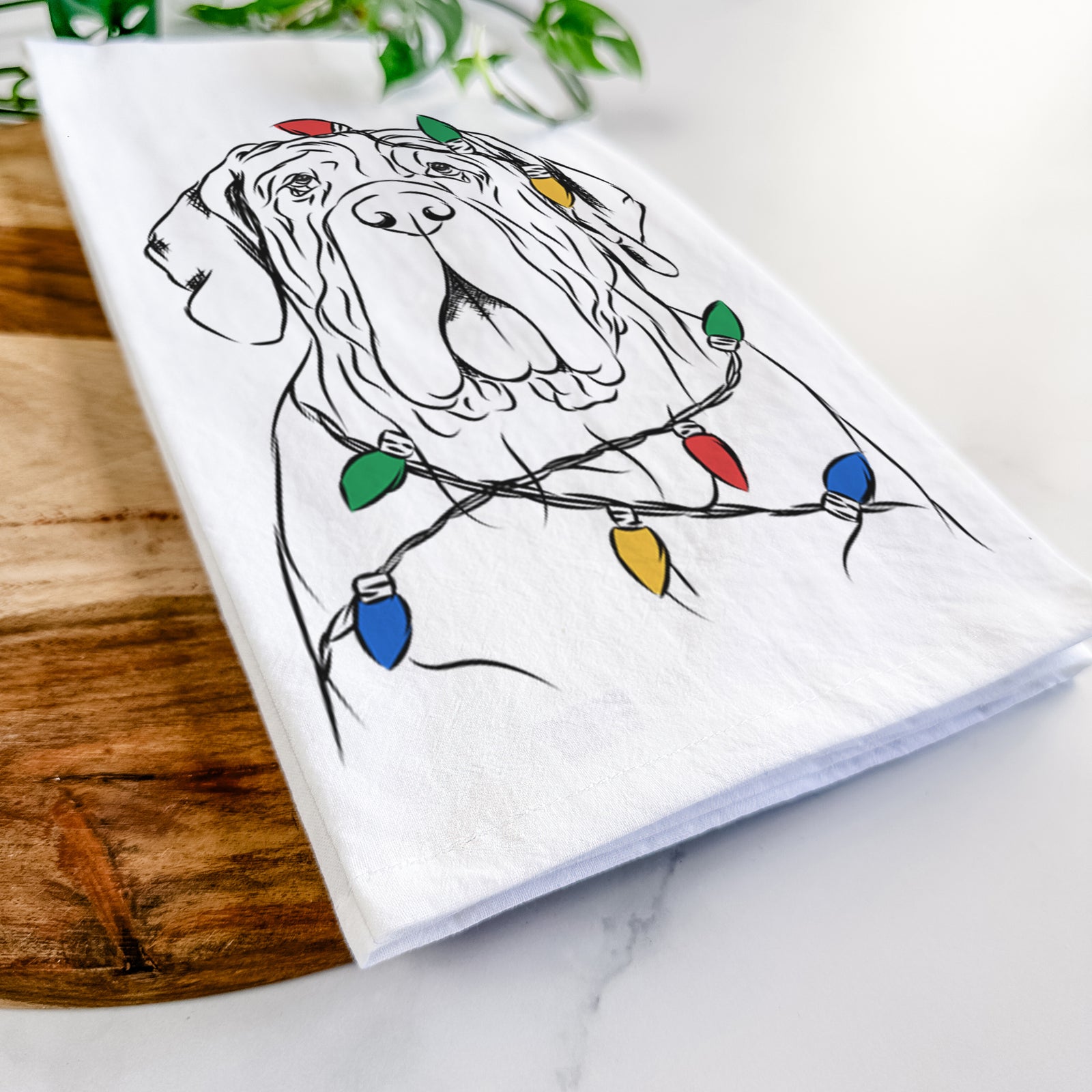 Hand-drawn sketch of Dinah the Neapolitan Mastiff wrapped in Christmas lights on a tea towel