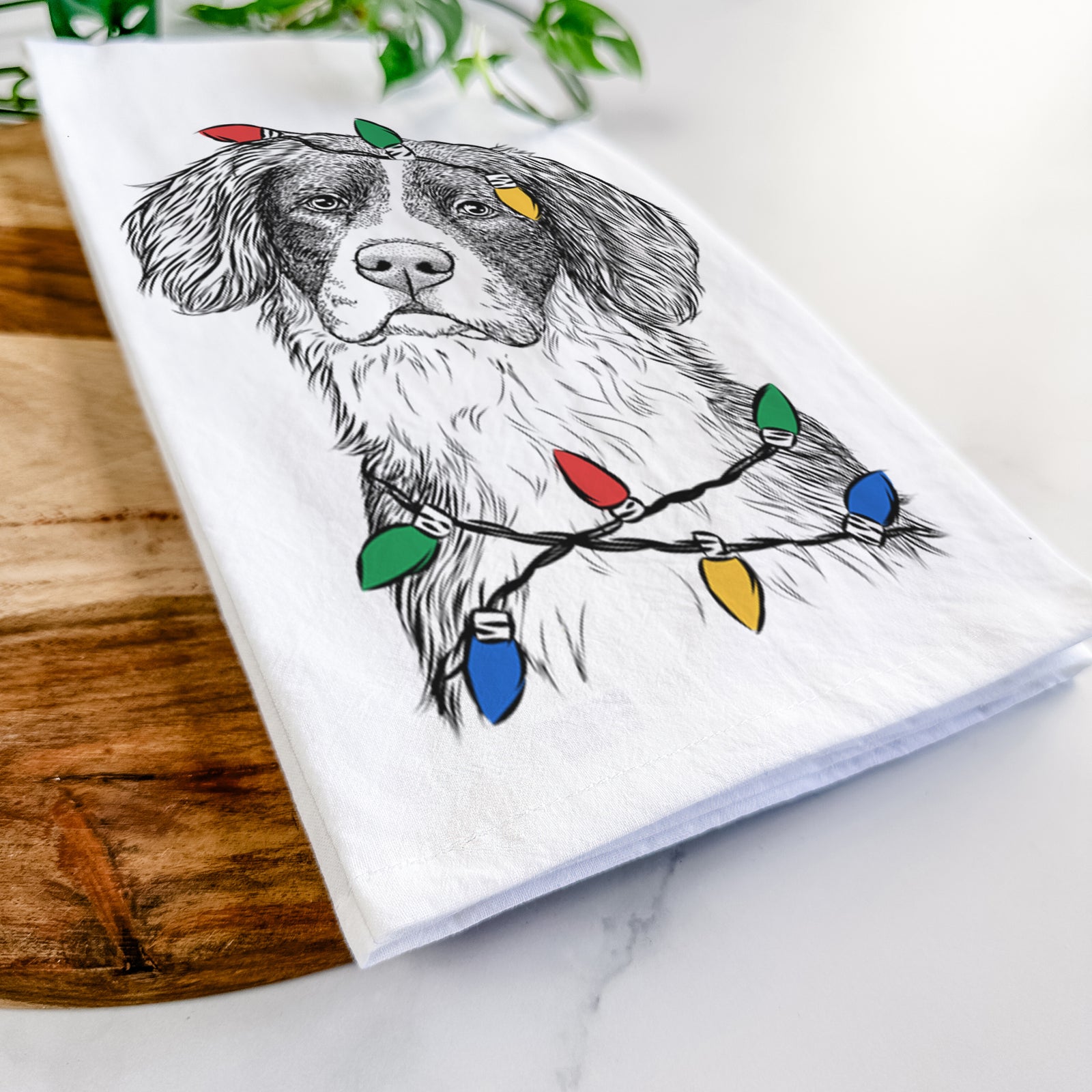 Hand-drawn sketch of Dulce the Drentsche Patrijshond wrapped in Christmas lights on a tea towel