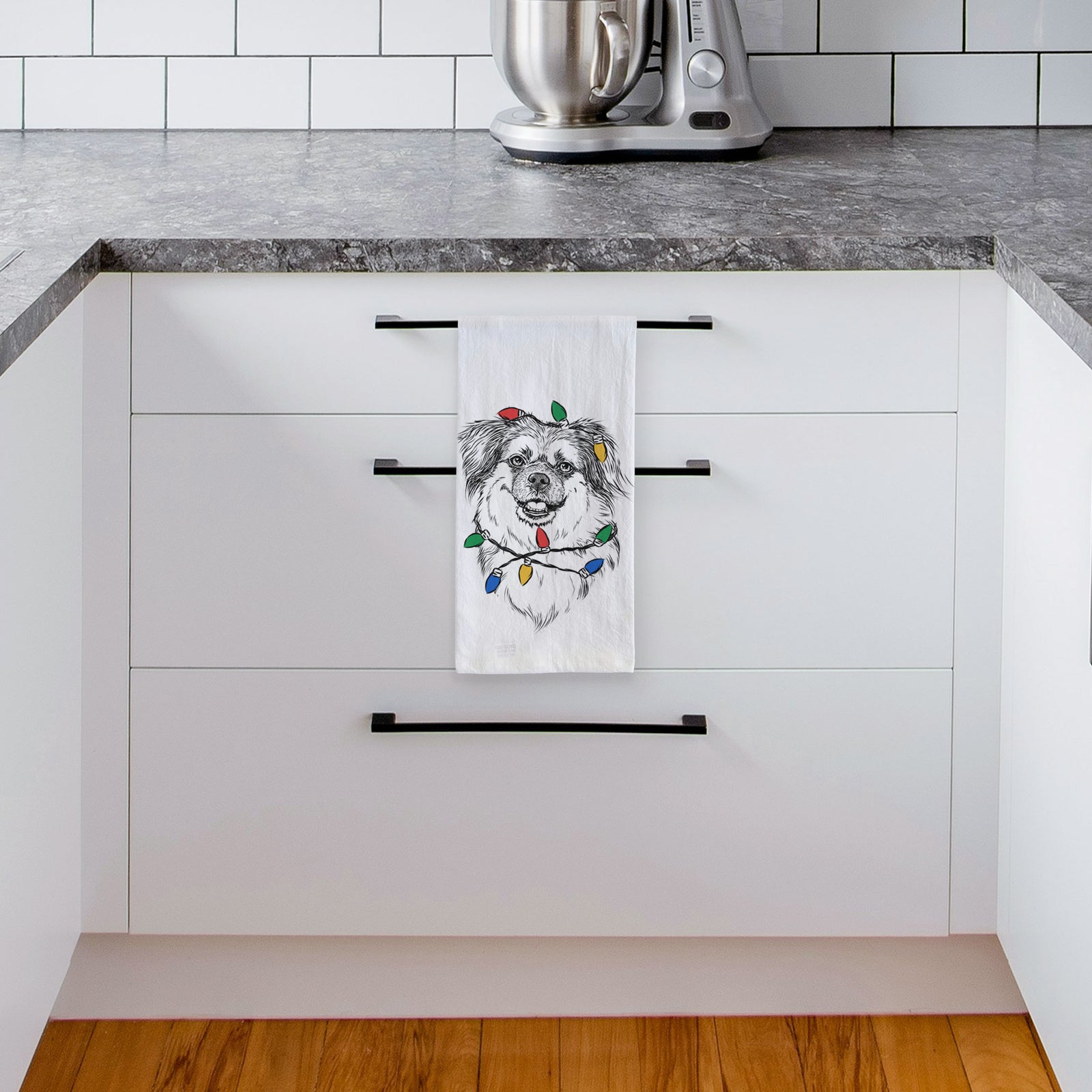 Hand-drawn sketch of Ed the Tibetan Spaniel wrapped in Christmas lights on a tea towel, hanging on an oven door in a kitchen