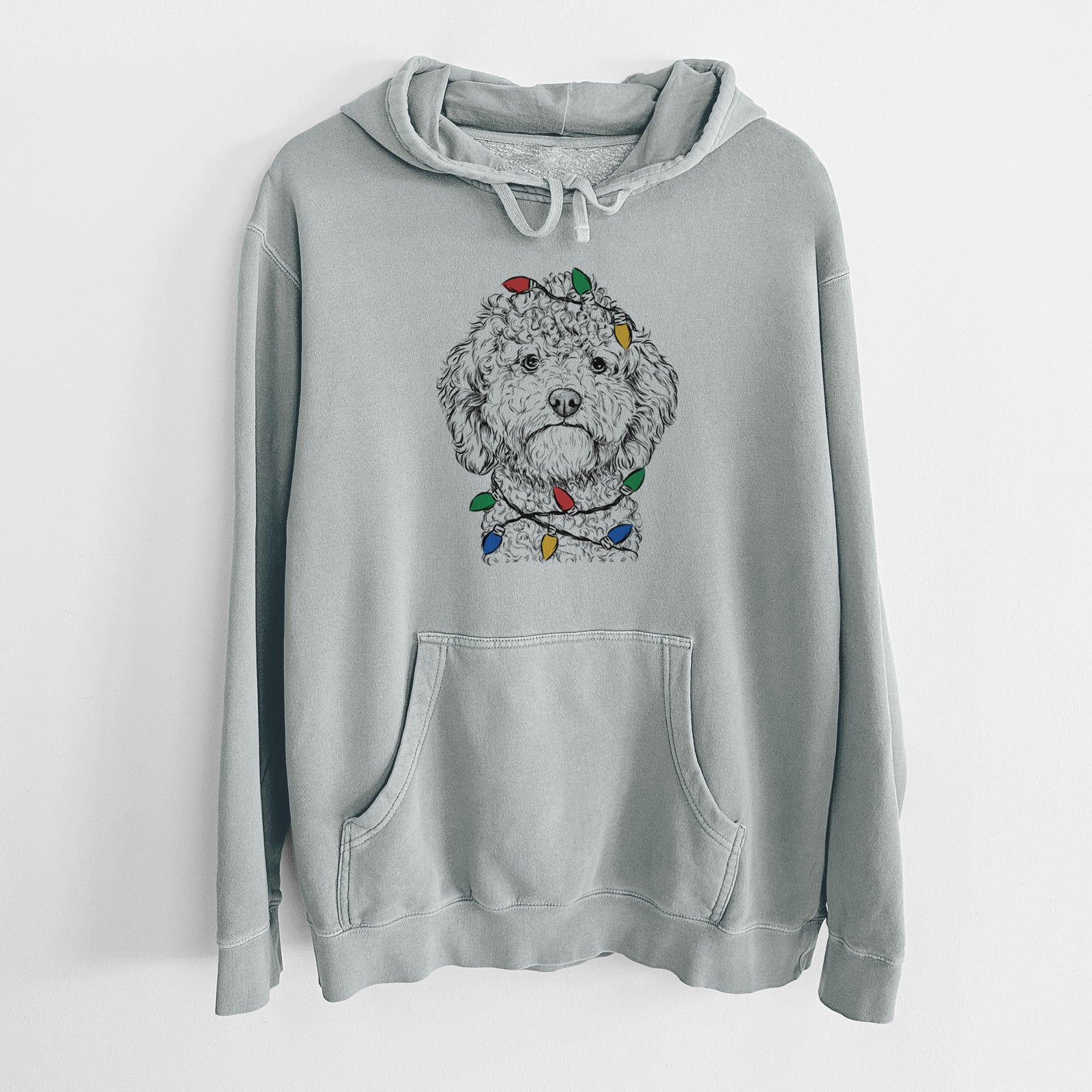Hand-drawn sketch of Edgar the Shihpoo wrapped in Christmas lights on a Sage Unisex pigment dyed hoodie