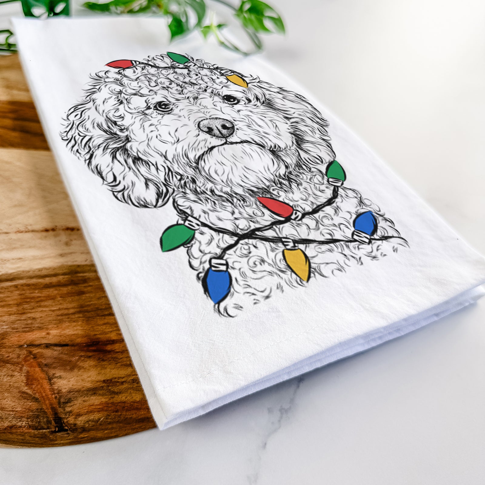 Hand-drawn sketch of Edgar the Shihpoo wrapped in Christmas lights on a tea towel