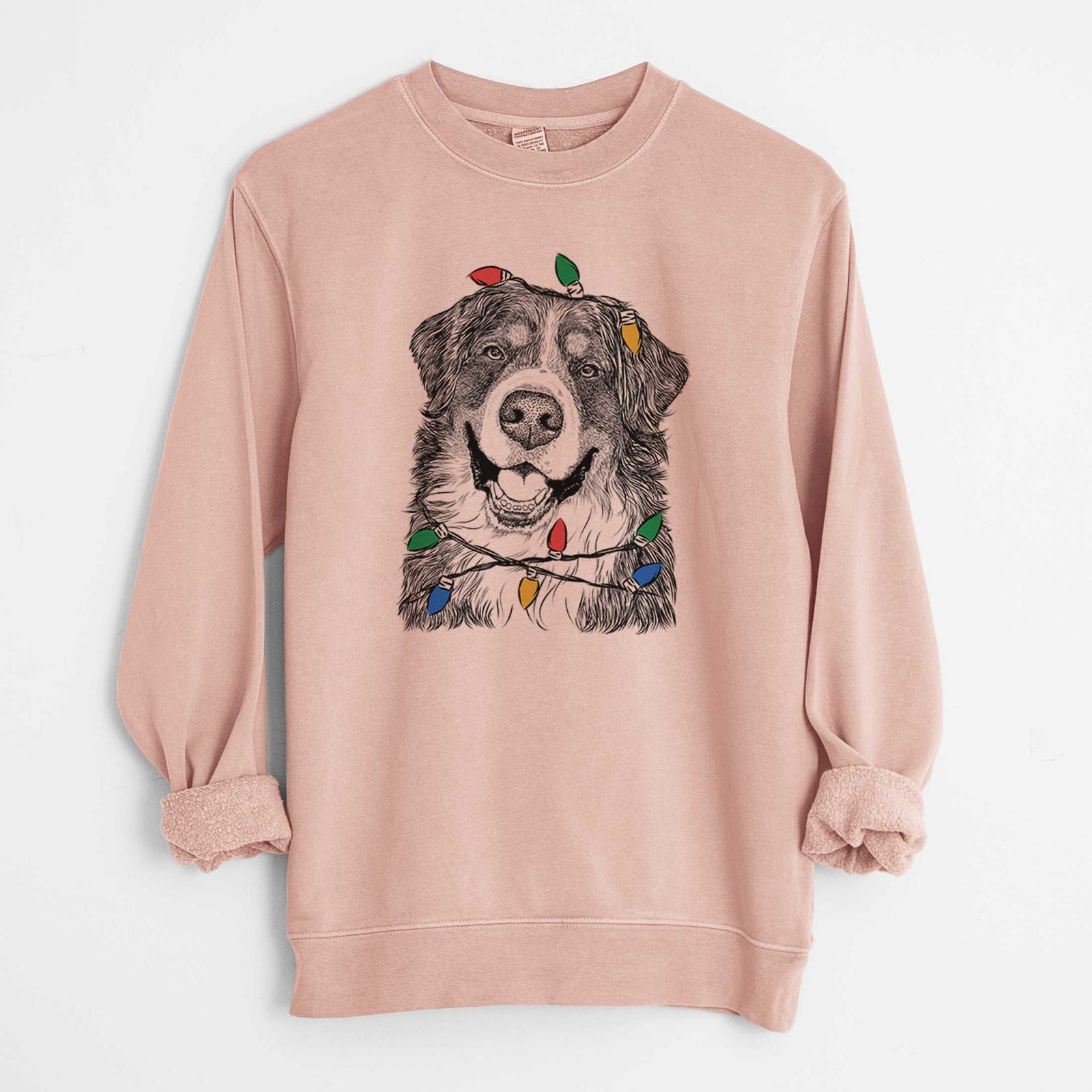 Hand-drawn sketch of Eiger the Bernese Mountain Dog wrapped in Christmas lights on a Dusty Pink Unisex pigment dyed crew sweatshirt