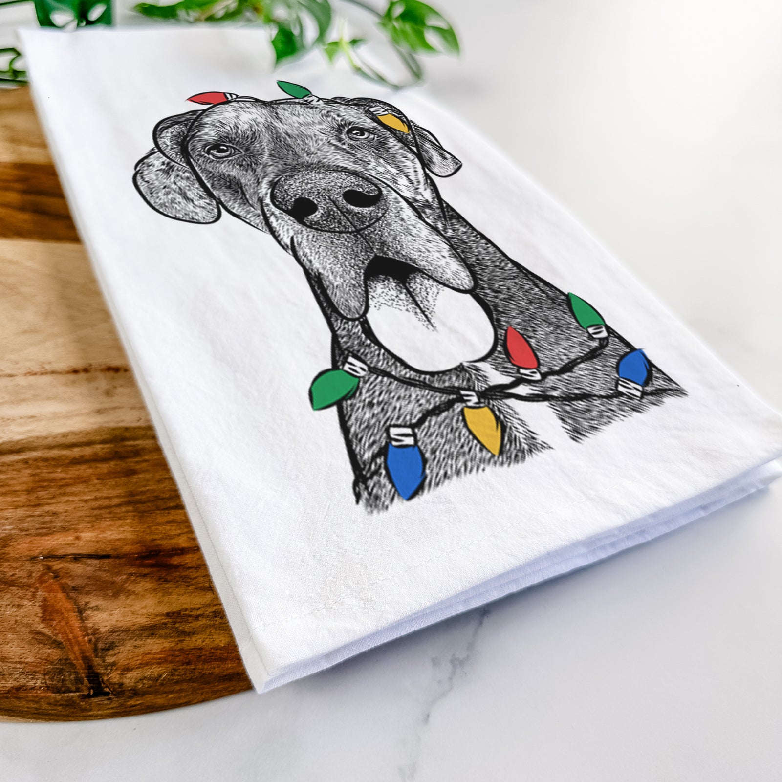 Hand-drawn sketch of Eli the Great Dane wrapped in Christmas lights on a tea towel