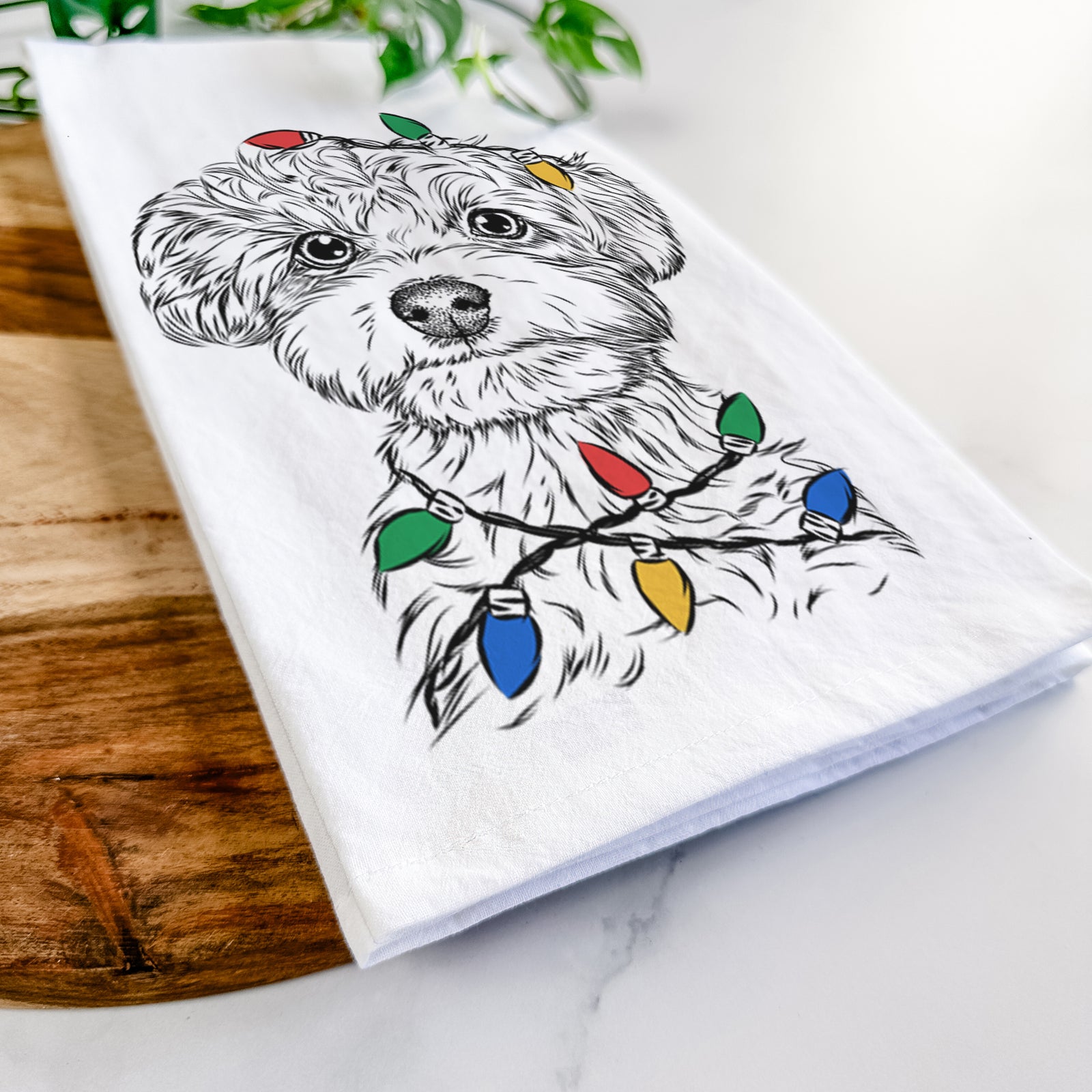 Hand-drawn sketch of Elliott the Yorkiepoo wrapped in Christmas lights on a tea towel