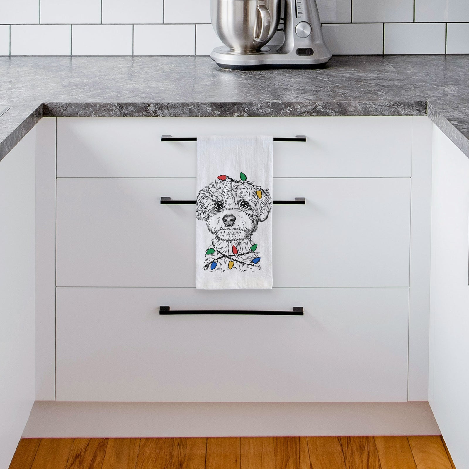Hand-drawn sketch of Elliott the Yorkiepoo wrapped in Christmas lights on a tea towel, hanging on an oven door in a kitchen