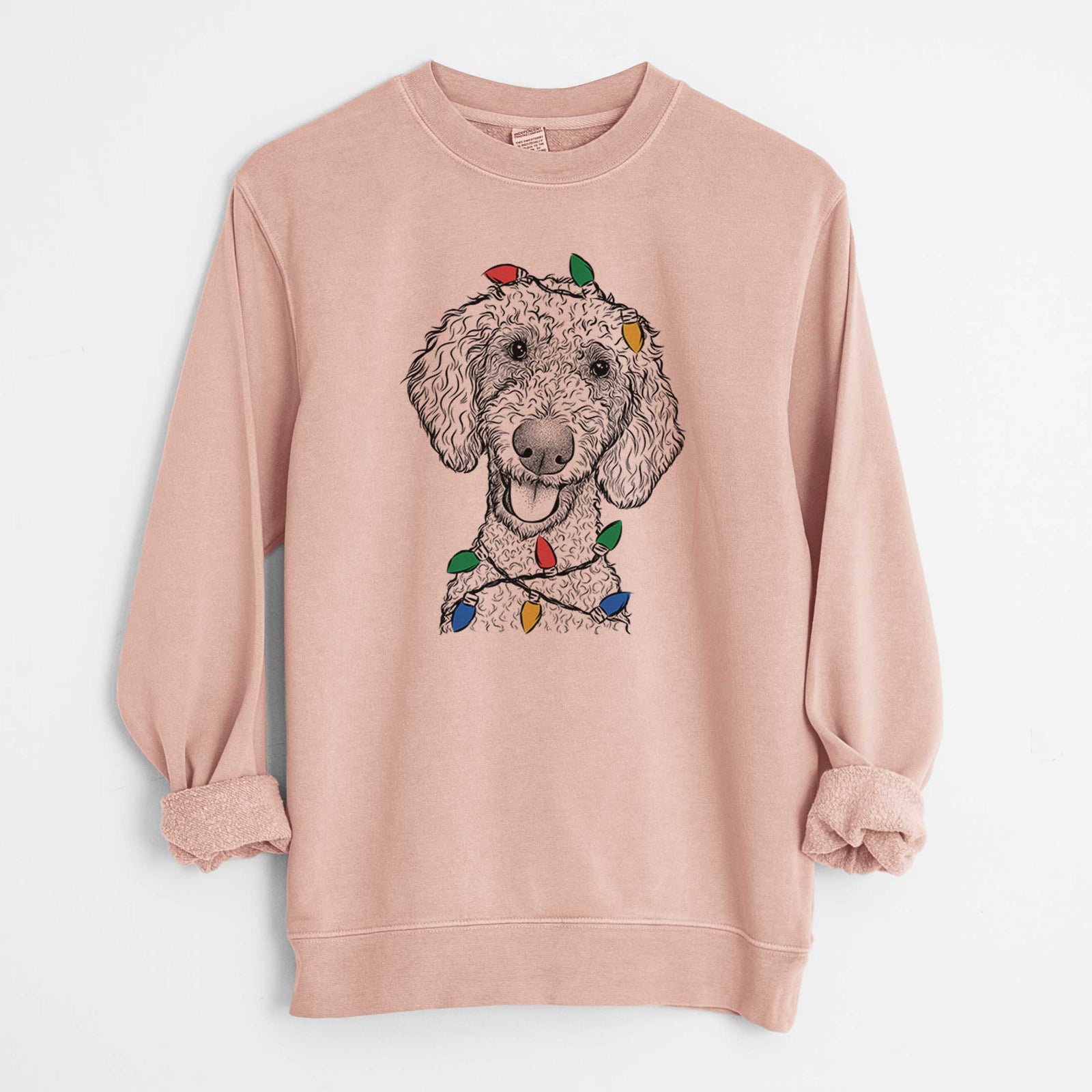 Hand-drawn sketch of Fenway the Goldendoodle wrapped in Christmas lights on a Dusty Pink Unisex pigment dyed crew sweatshirt