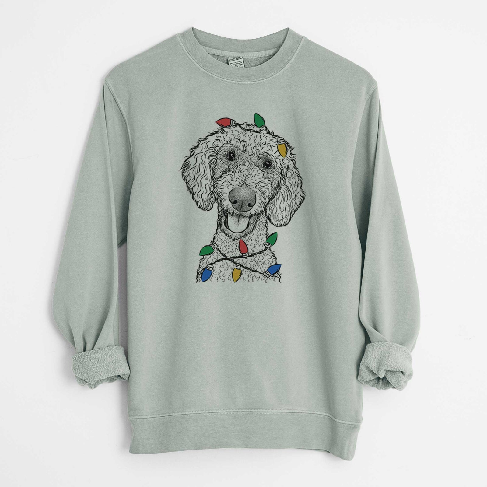 Hand-drawn sketch of Fenway the Goldendoodle wrapped in Christmas lights on a Sage Unisex pigment dyed crew sweatshirt