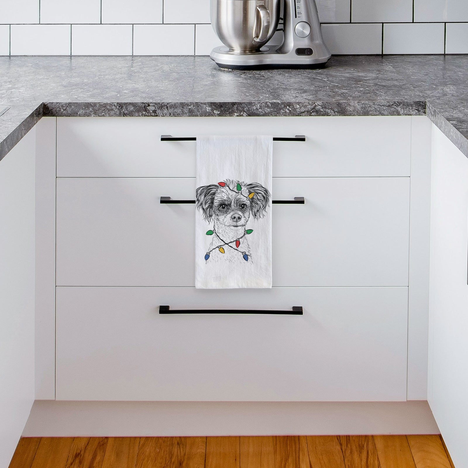 Hand-drawn sketch of Finley the Papillon Mix wrapped in Christmas lights on a tea towel, hanging on an oven door in a kitchen
