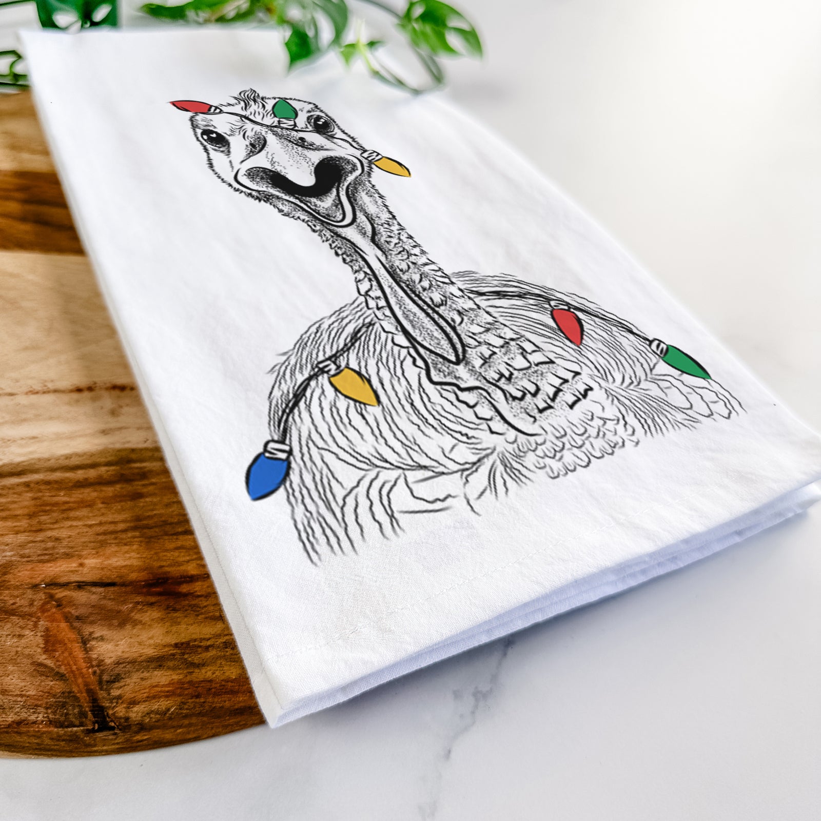 Hand-drawn sketch of Gobble the Turkey wrapped in Christmas lights on a tea towel