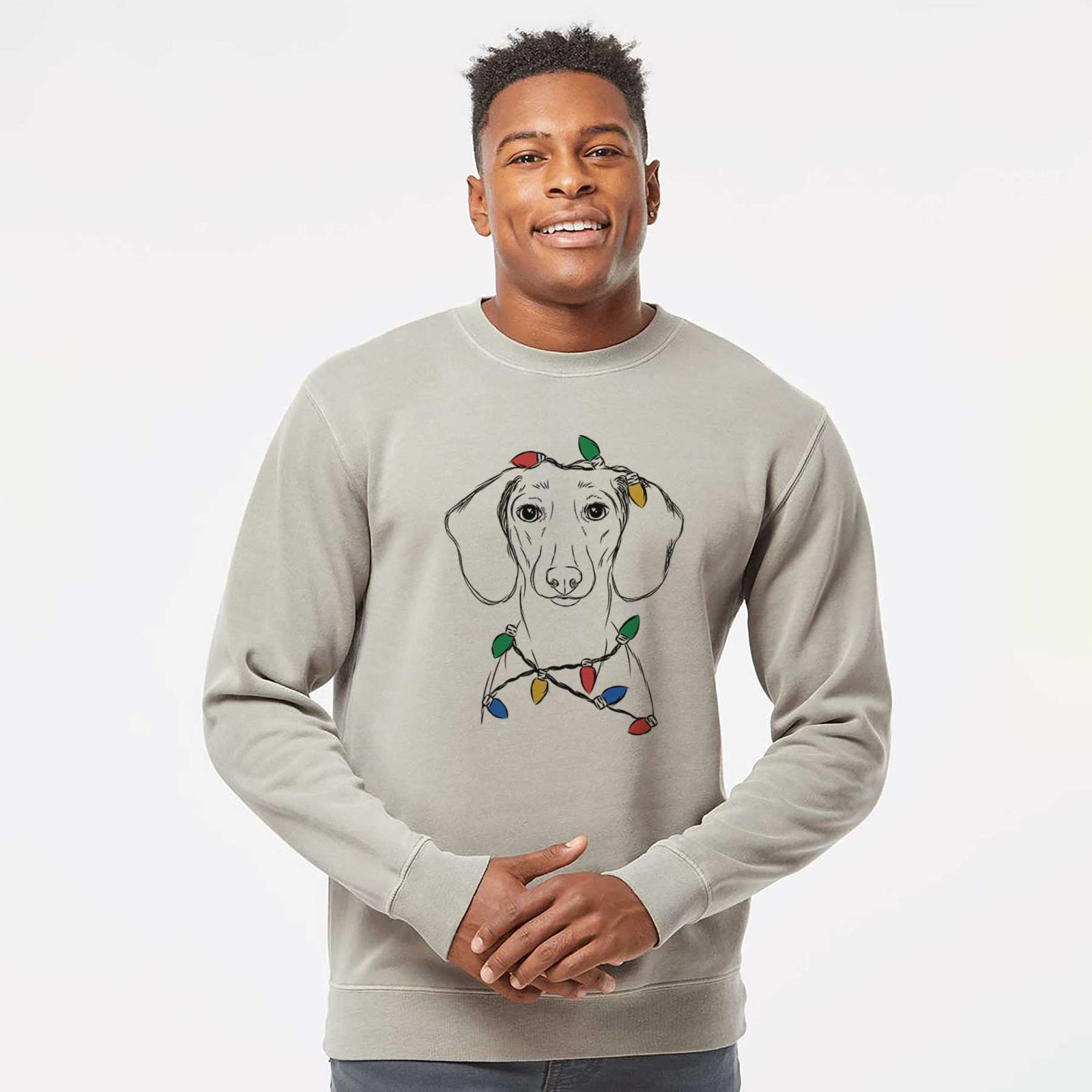 Hand-drawn sketch of Hans the Dachshund wrapped in Christmas lights on a Cement Unisex pigment dyed crew sweatshirt