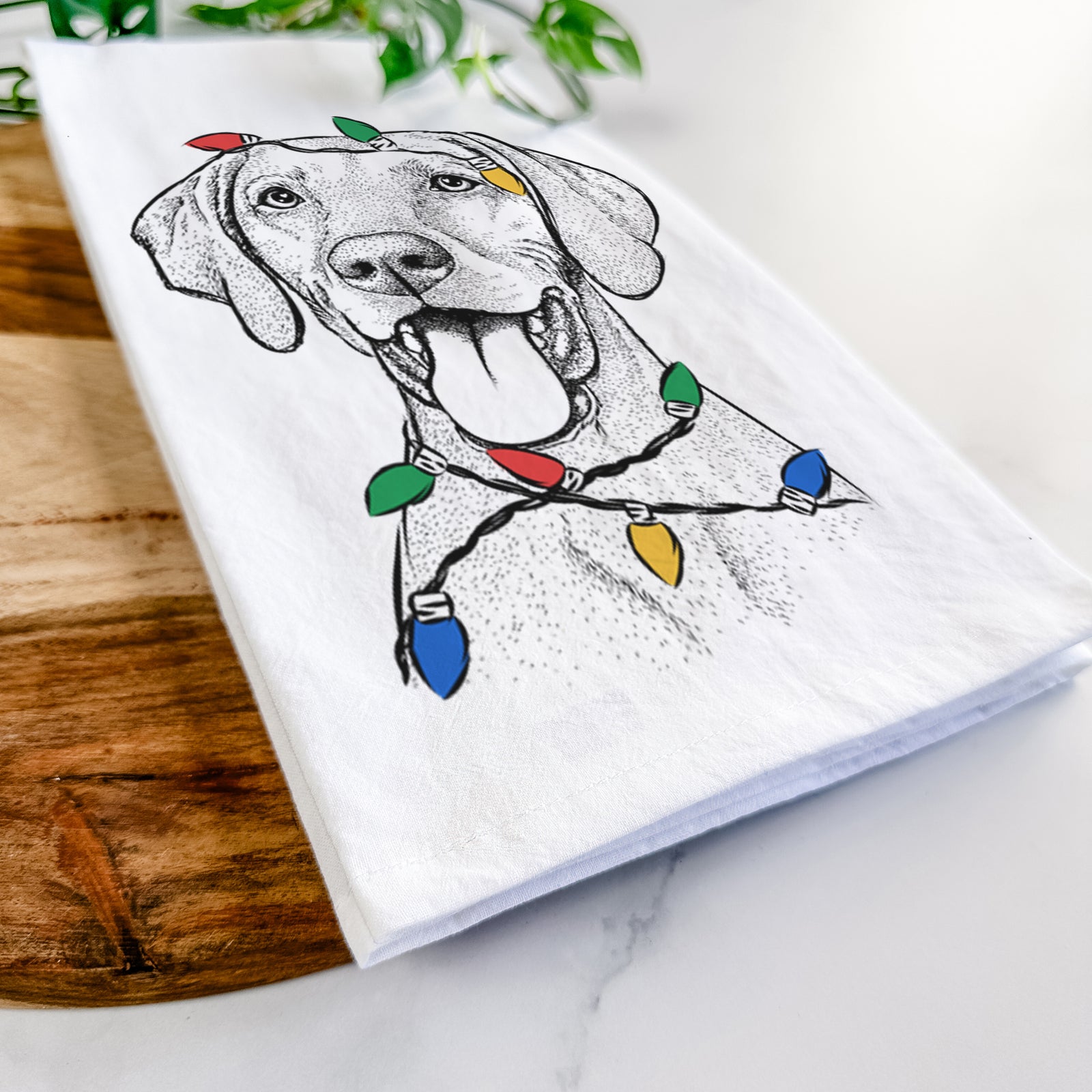 Hand-drawn sketch of Harper the Vizsla wrapped in Christmas lights on a tea towel