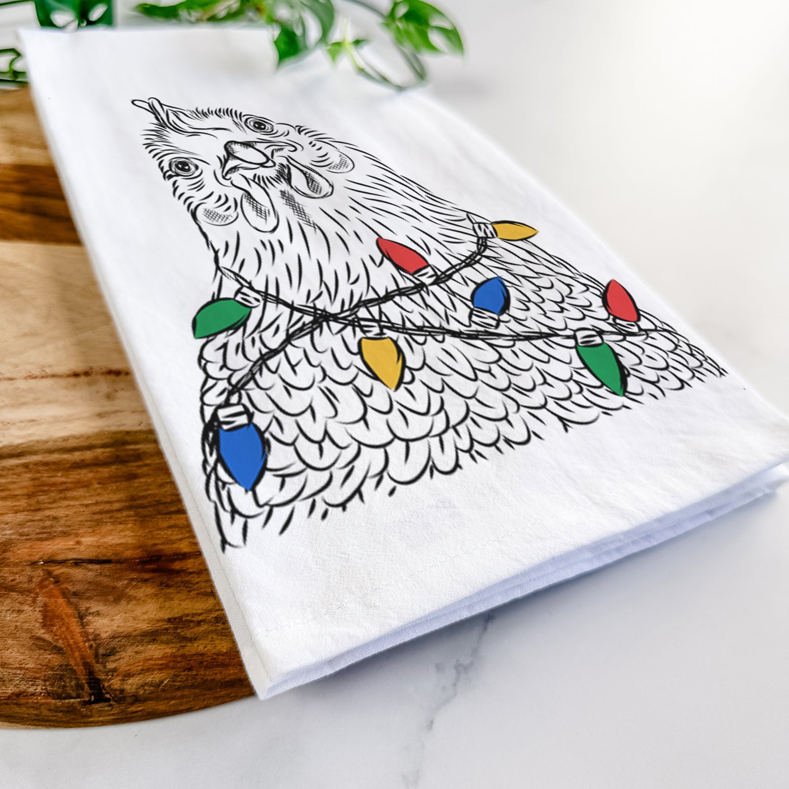 Hand-drawn sketch of Henrietta the Chicken wrapped in Christmas lights on a tea towel