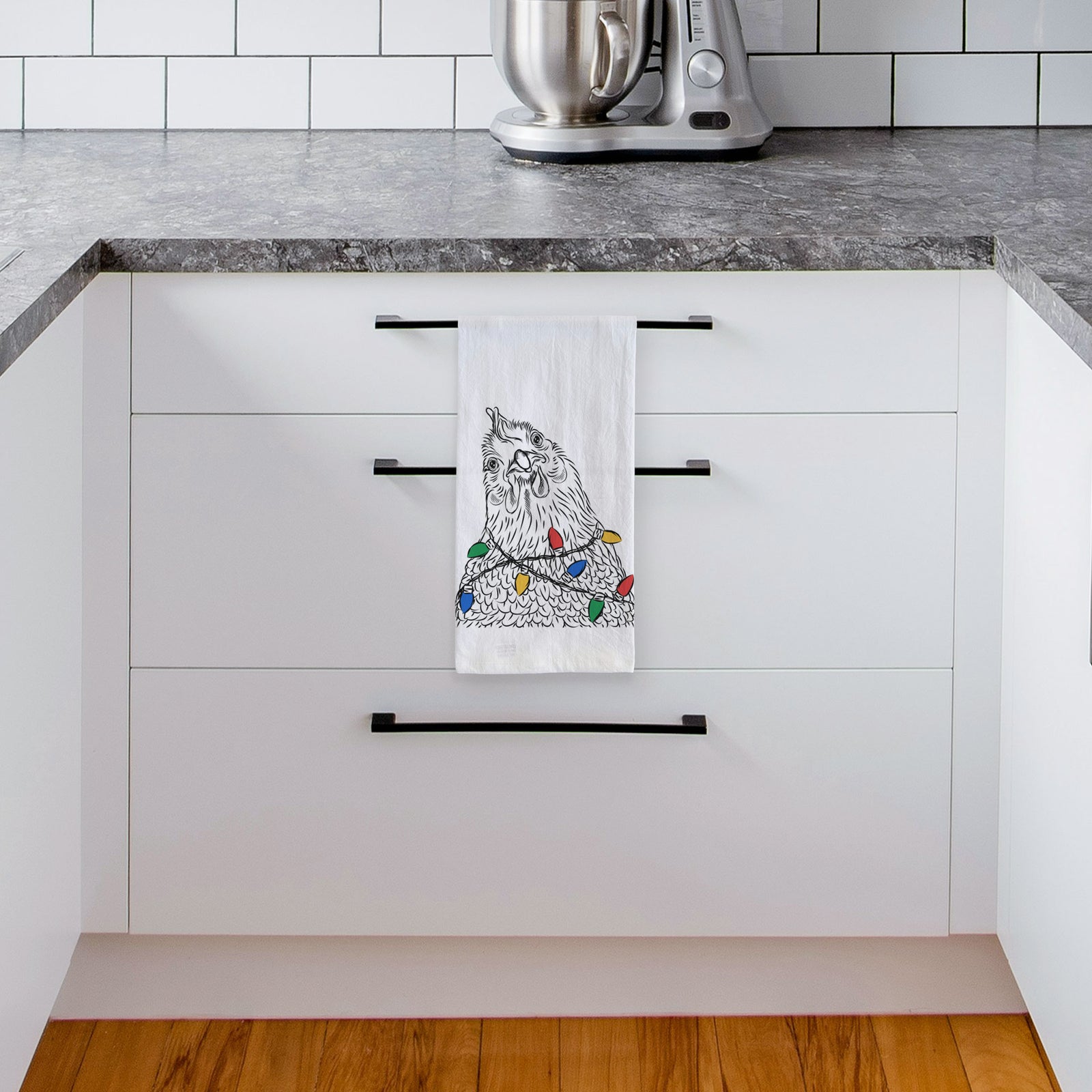 Hand-drawn sketch of Henrietta the Chicken wrapped in Christmas lights on a tea towel, hanging on an oven door in a kitchen